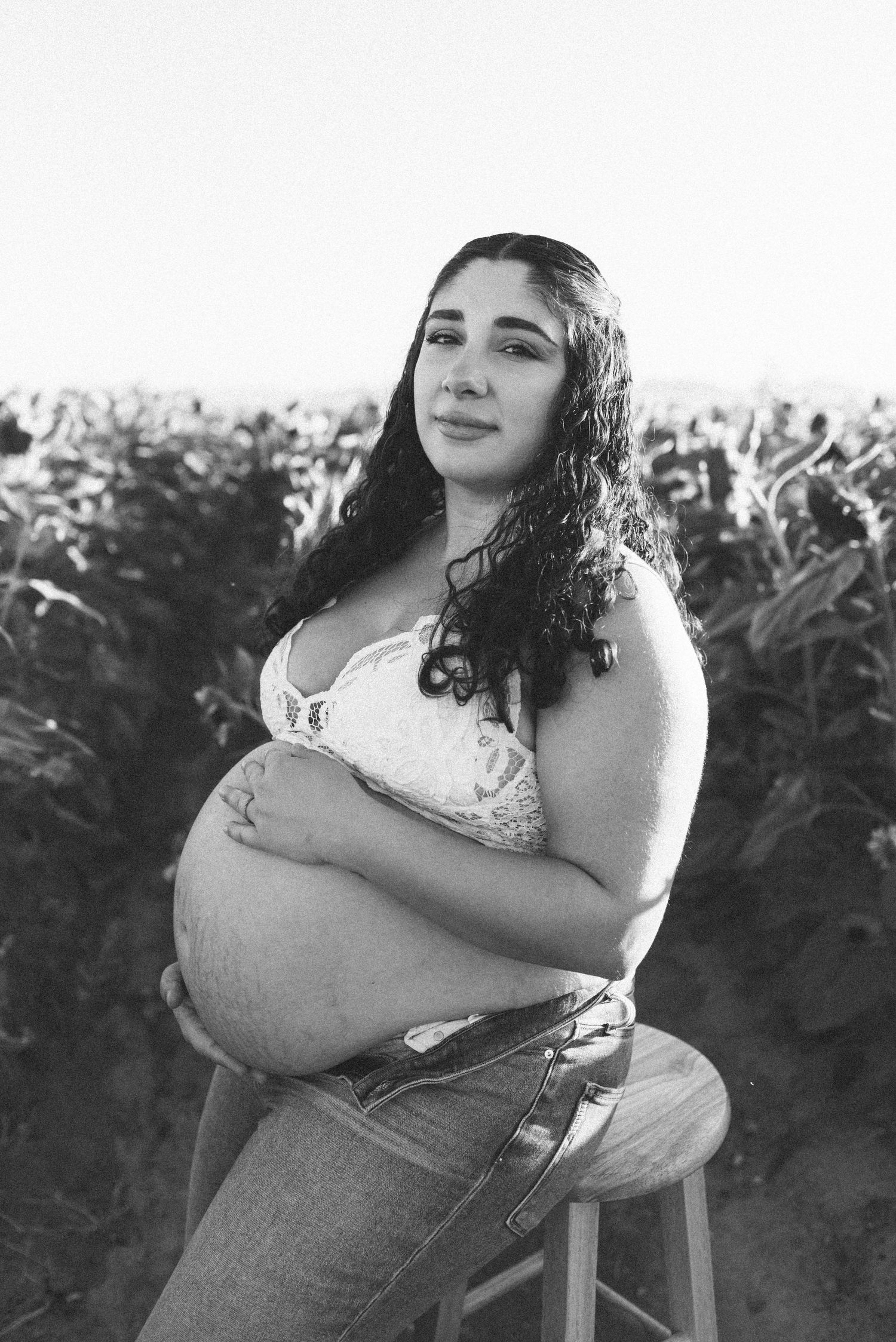 Black and white photo of pregnant woman in sunflower field