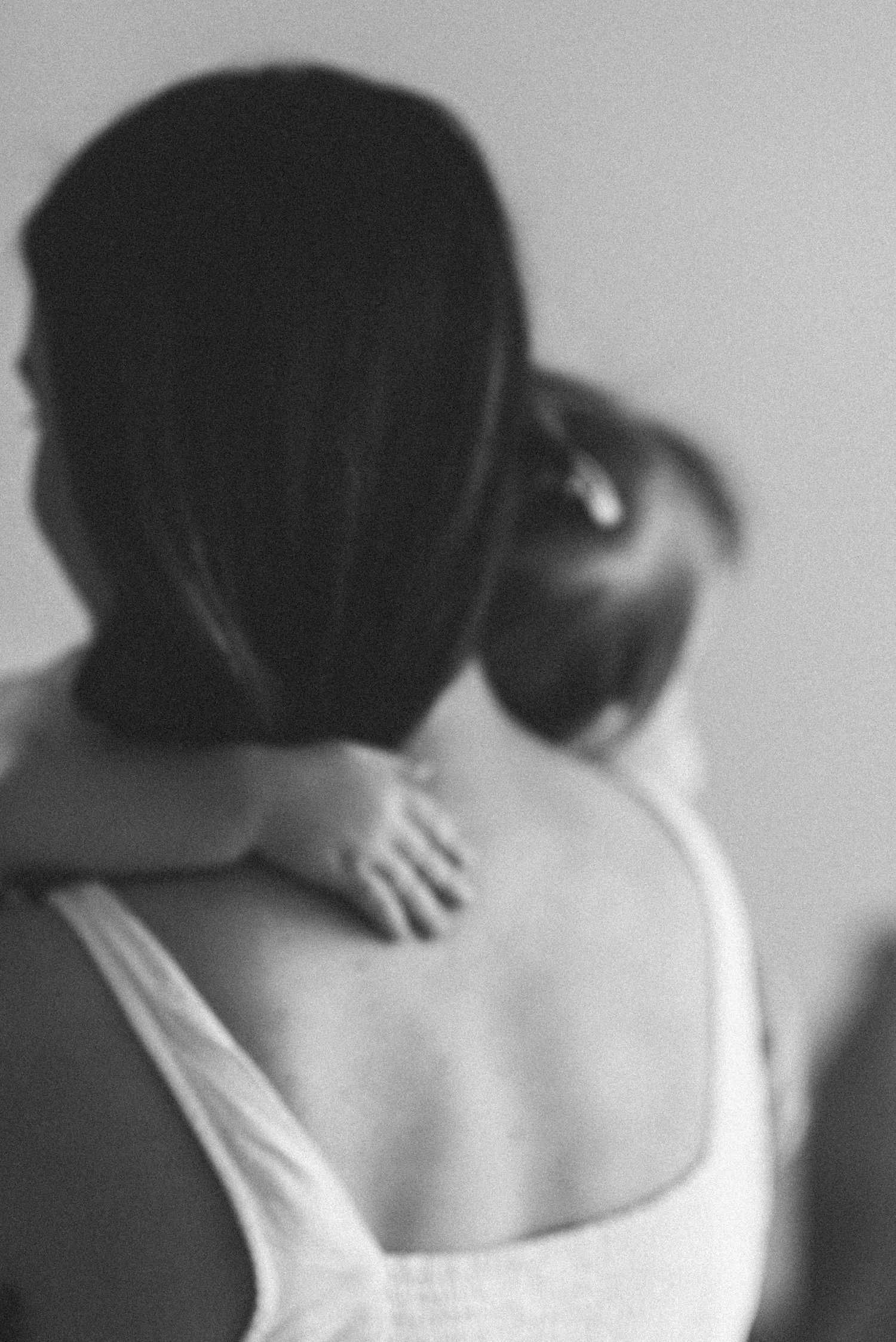 An artistic black and white portrait showing gentle movement and soft focus.