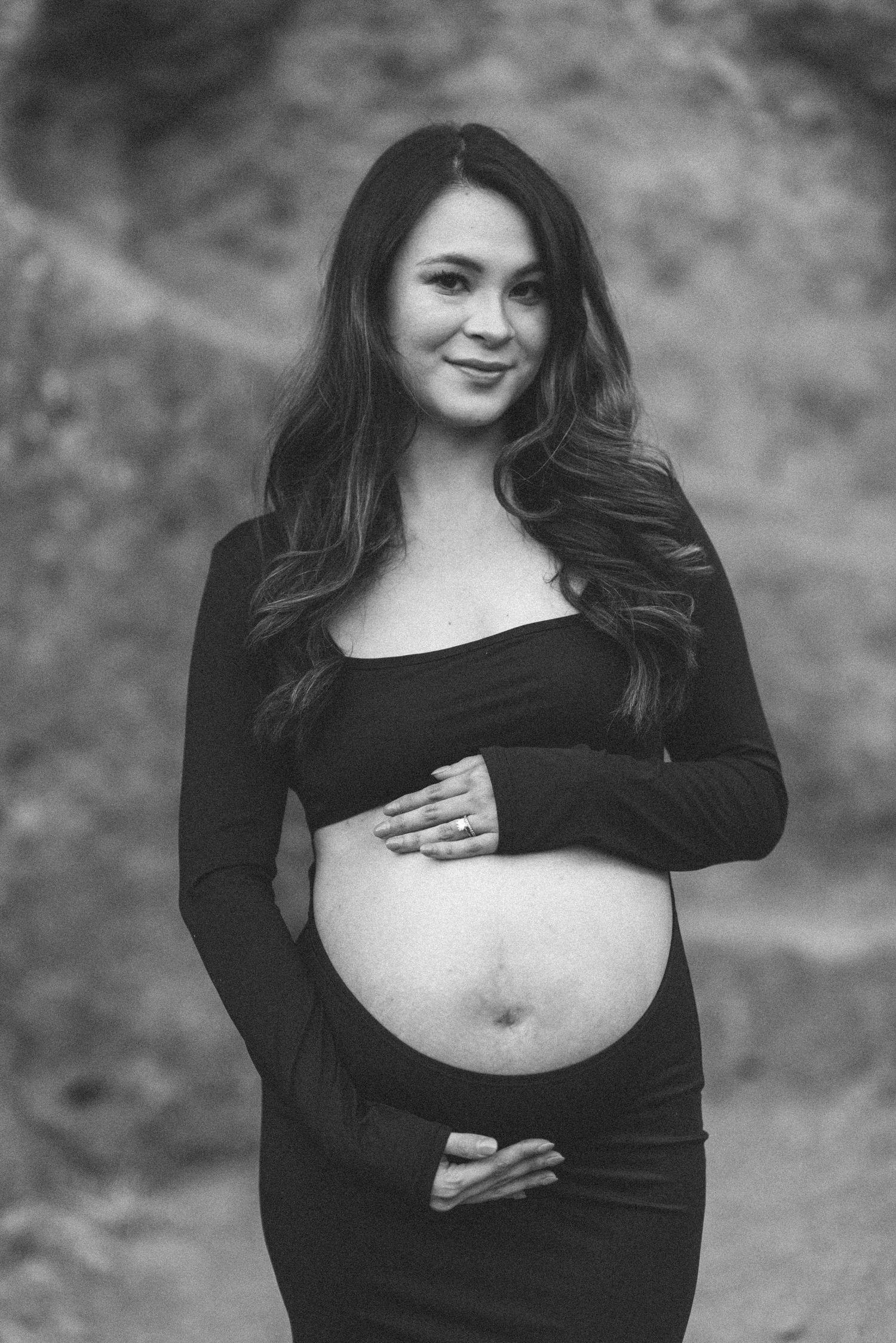 Black and white maternity photo series showing a pregnant woman in a black top against a blurred background.