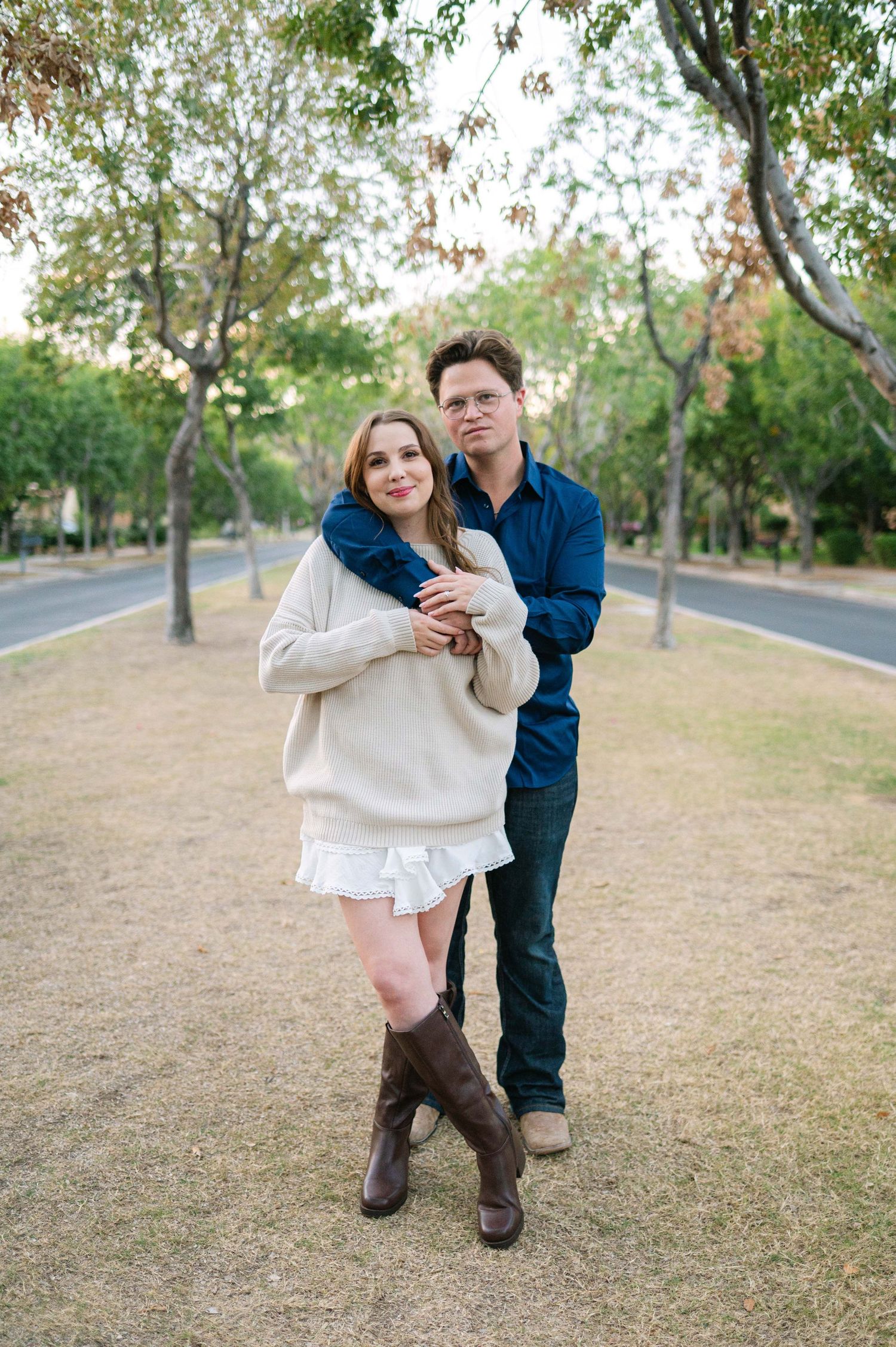 Playful outdoor photoshoot in a park with trees in the background.