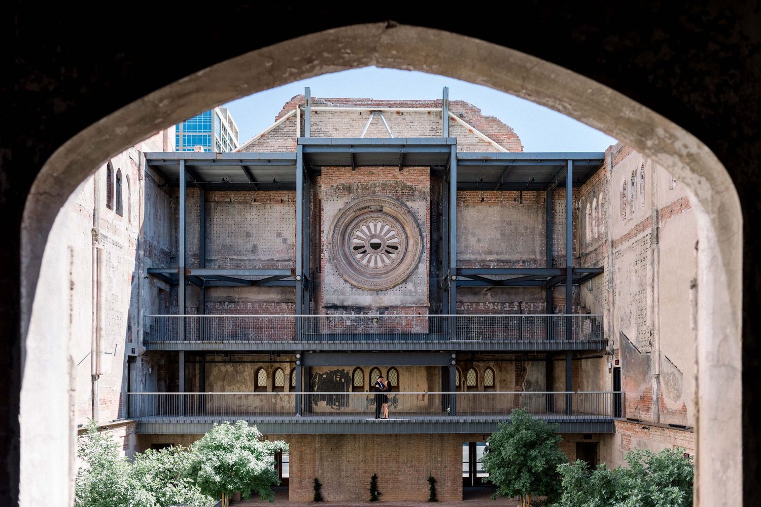Historic architectural detail showing ornate balcony through stone archway.
