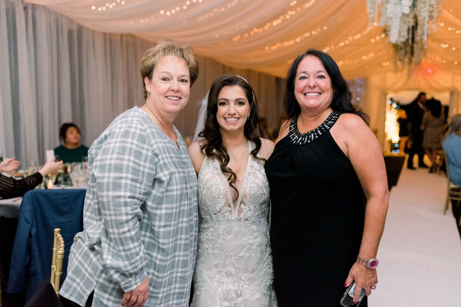 Wedding reception guests posing together in decorated indoor venue.