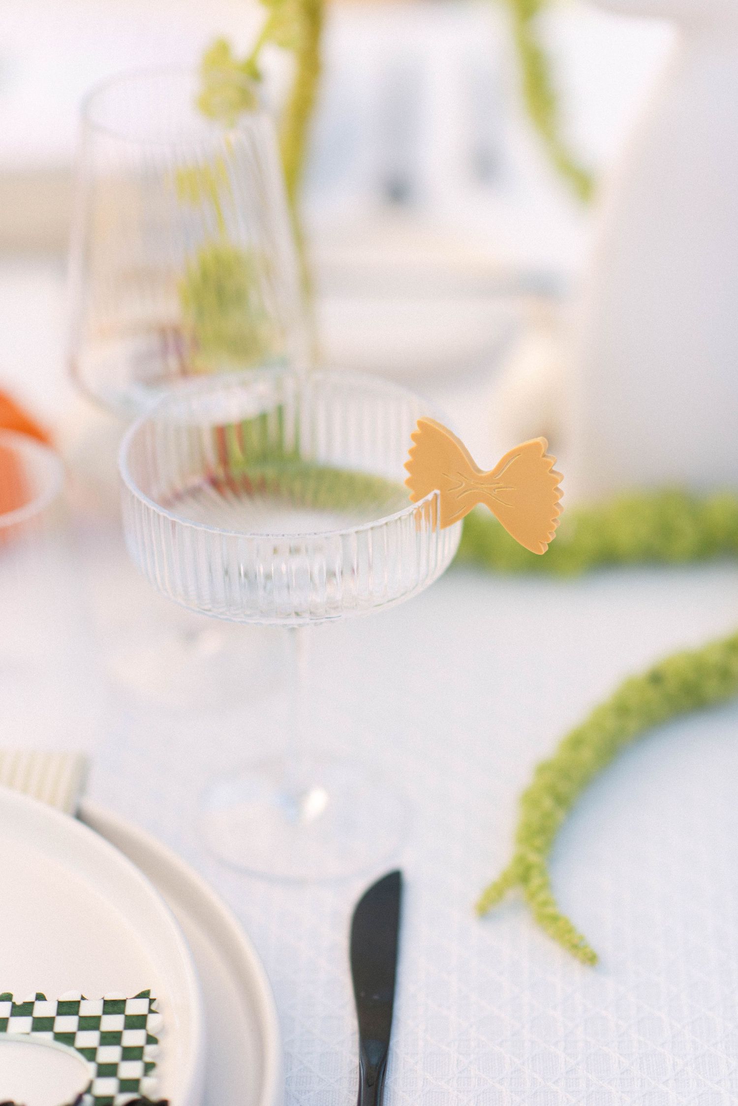 Place settings with butterfly decorations and delicate glassware at wedding reception.