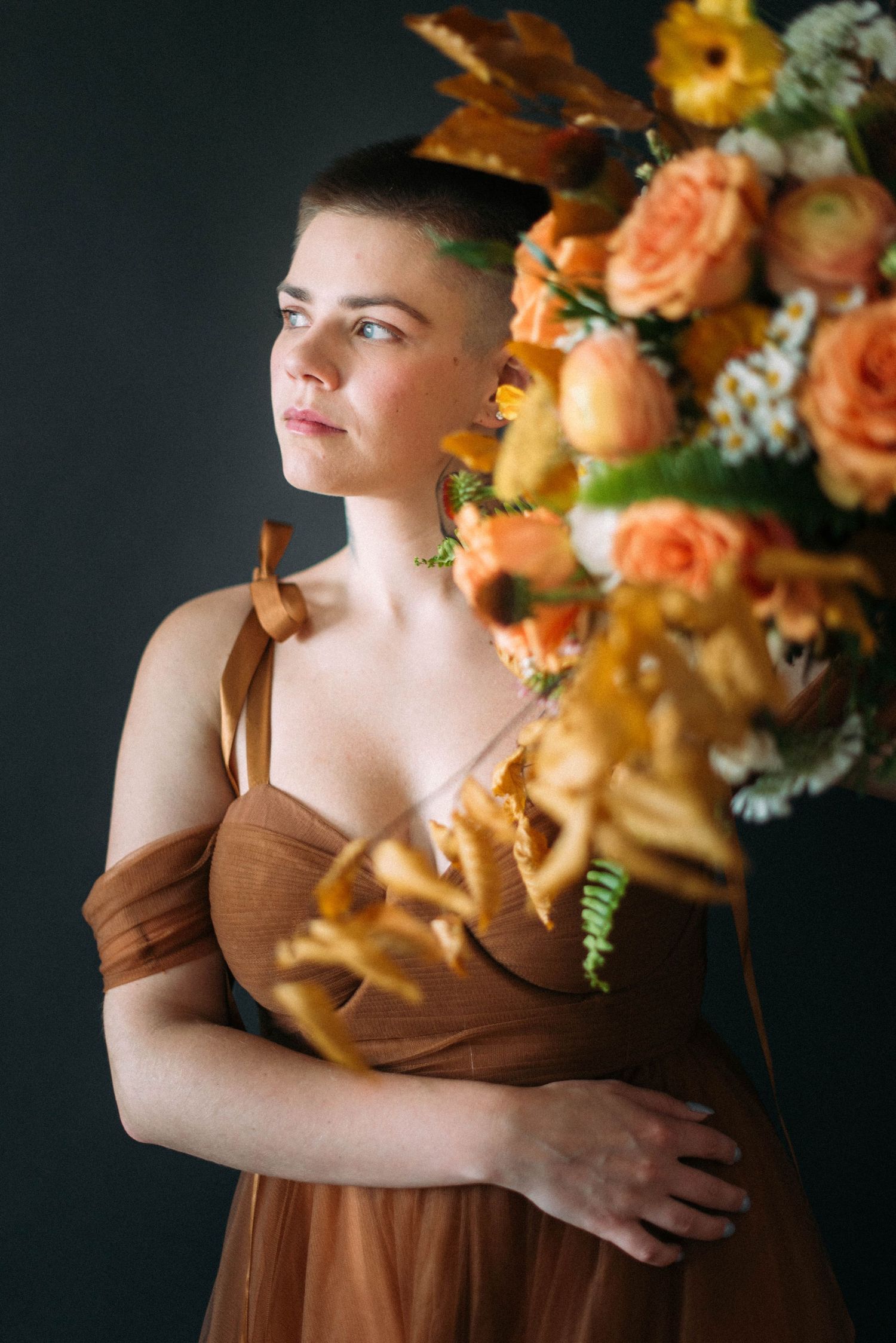 A dramatic side profile portrait with peach roses and autumn foliage.