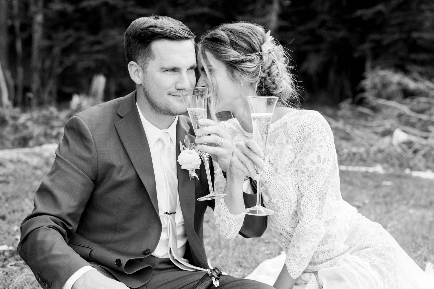 Black and white portrait of couple sharing intimate moment with champagne.