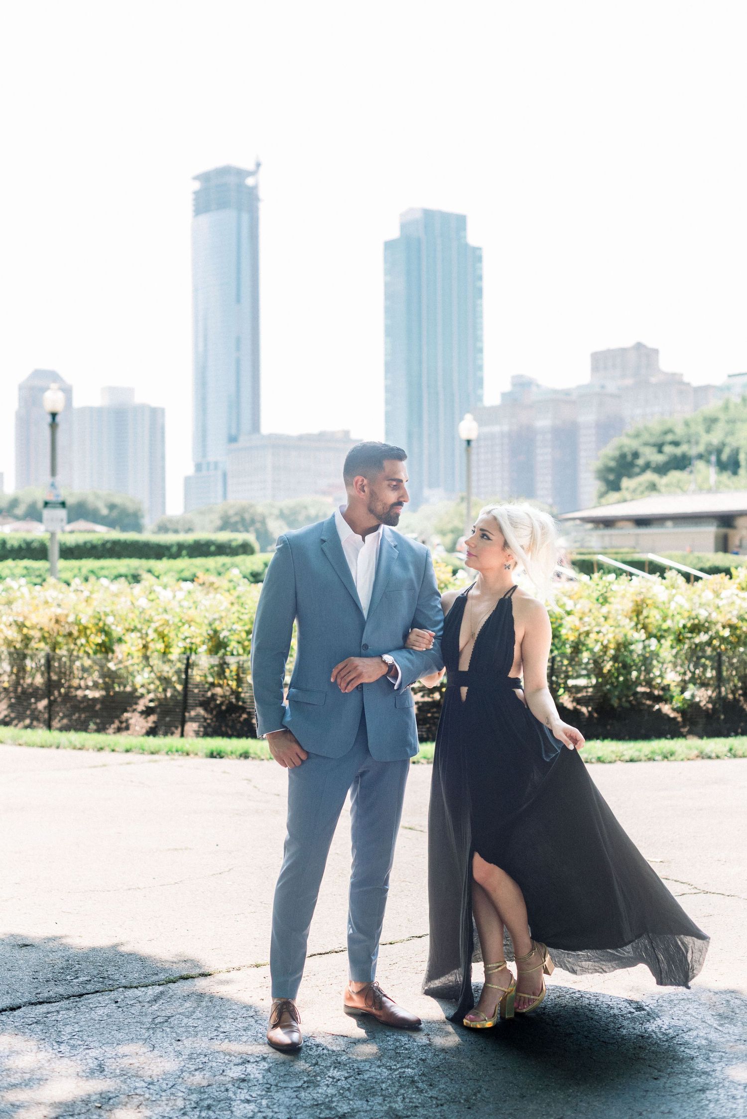 Elegant couple in formal wear posing against Chicago city skyline.