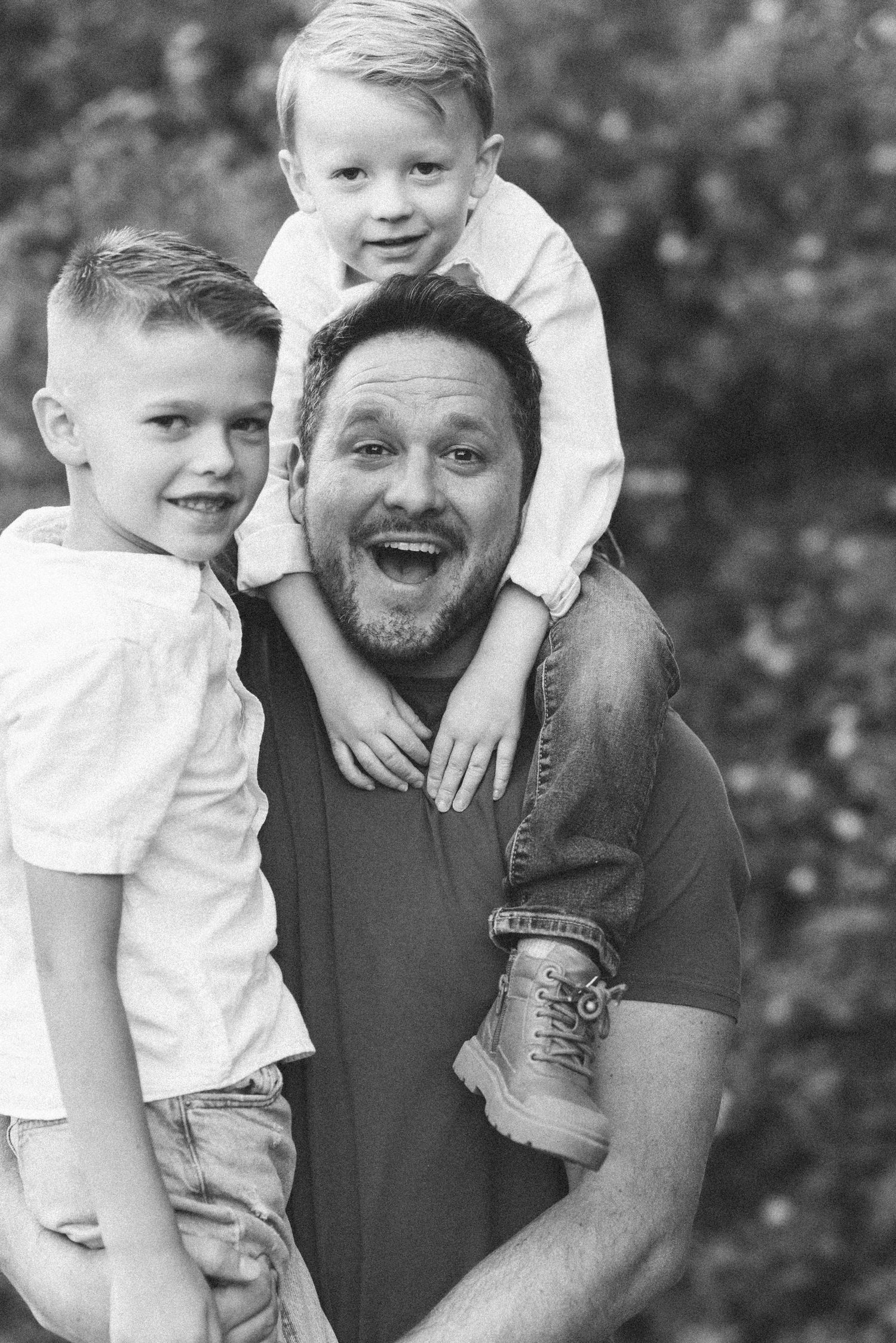 A black and white photo series showing joyful candid moments between a parent and child outdoors.