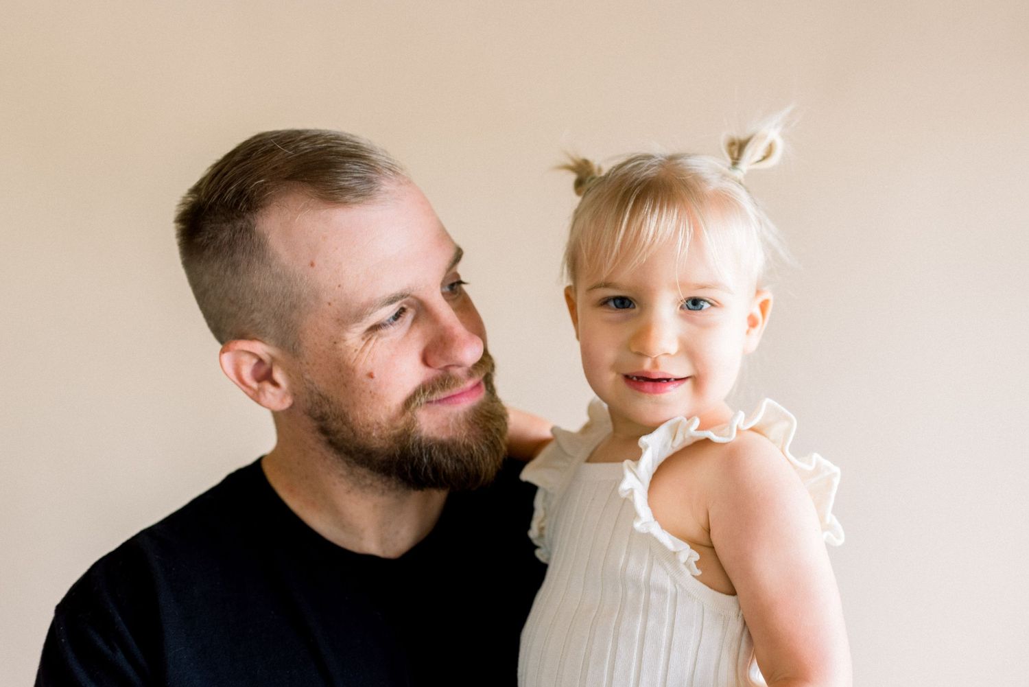 Tender family moment captured during a professional photo session against neutral background.