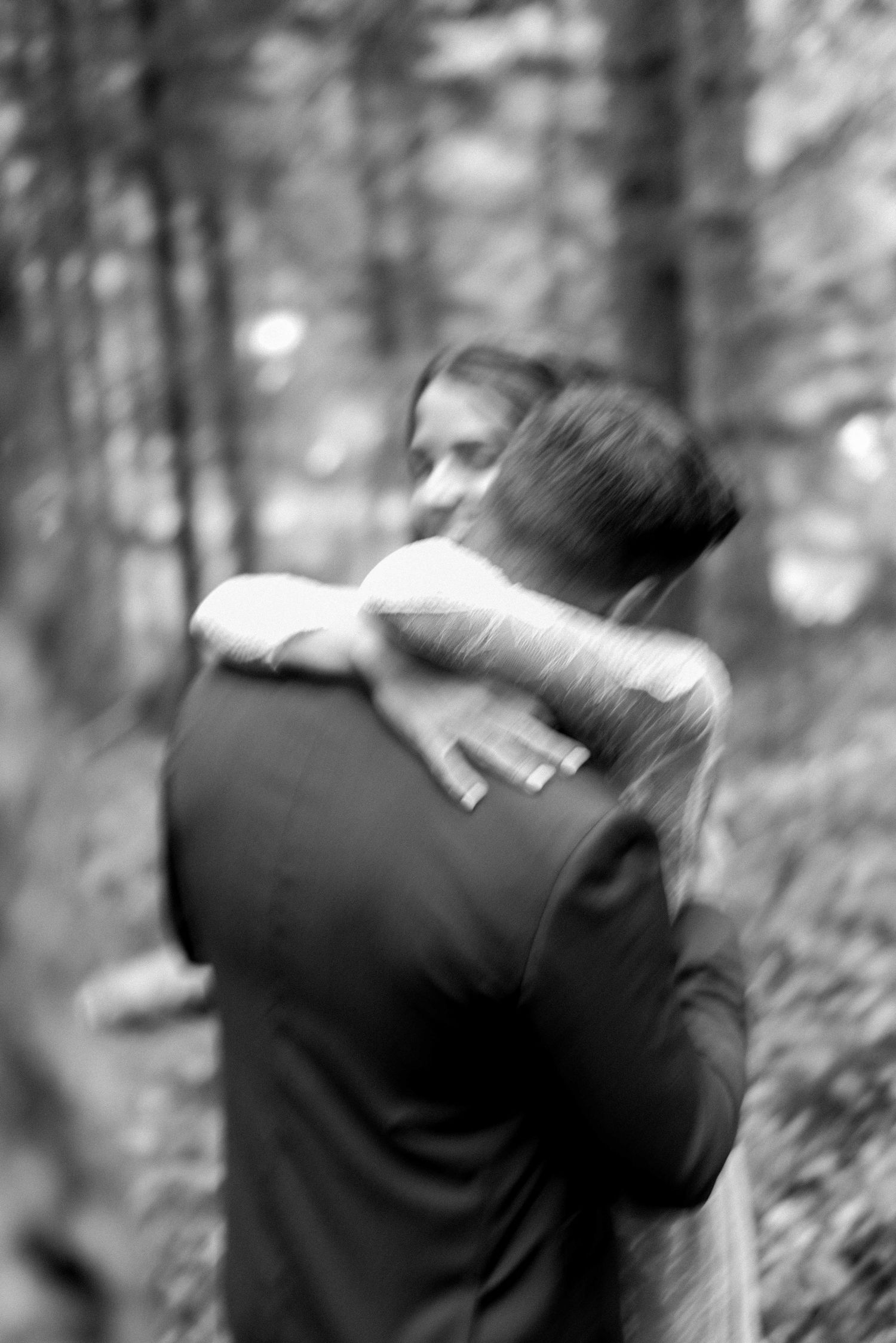 A black and white intimate embrace during a woodland wedding ceremony.