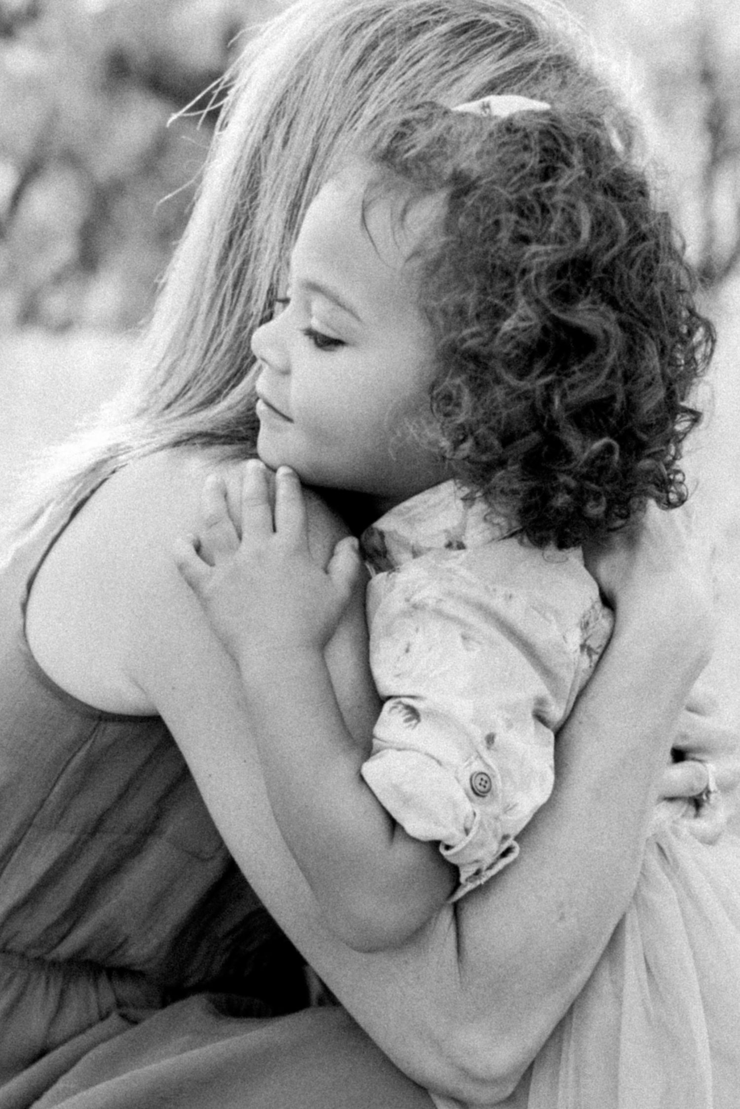 Black and white tender moment between mother and child in embrace.