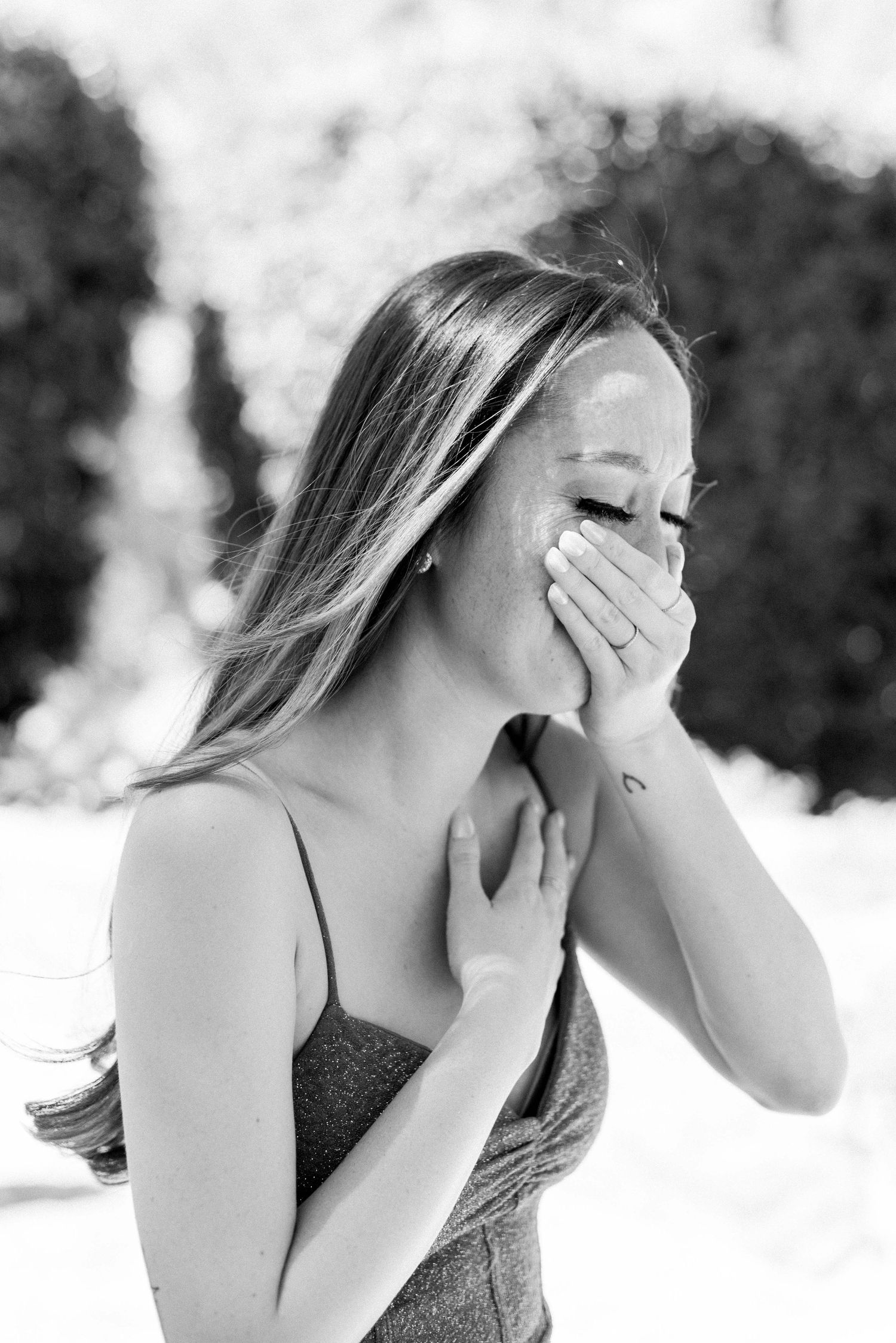 Emotional moment captured in black and white as woman covers her face with hands.