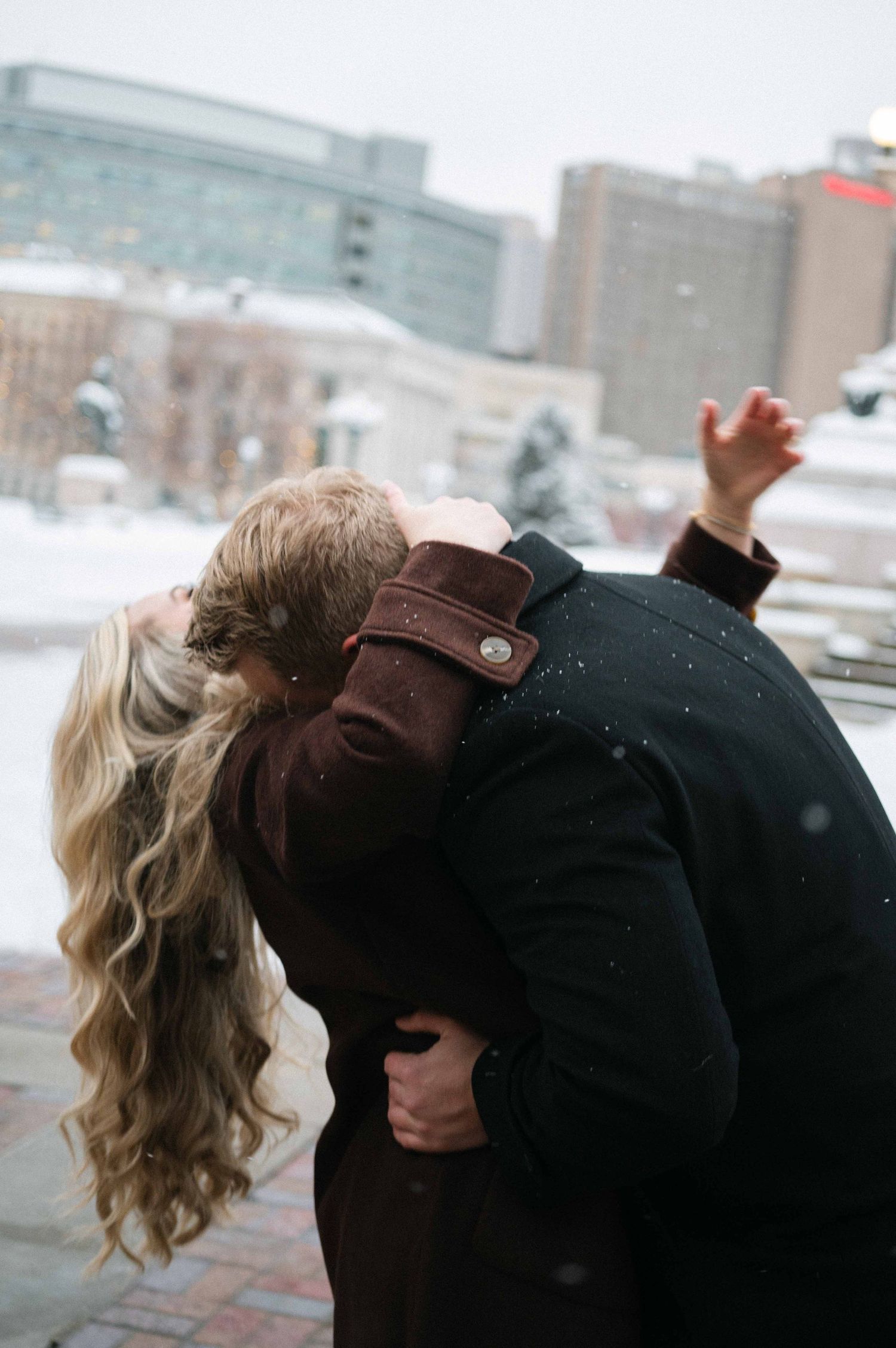 A couple shares an intimate moment while dancing in the snow.