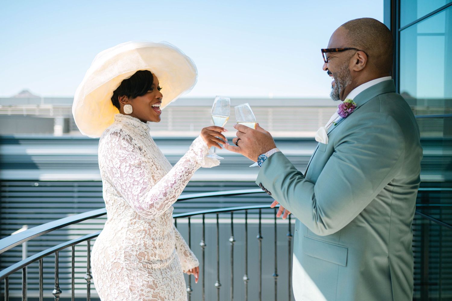 A couple interacting playfully by a glass window in an urban setting.