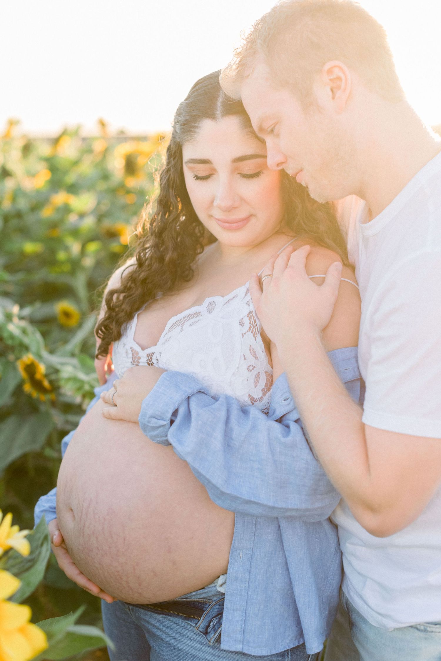 Maternity photo of couple in sunflower field