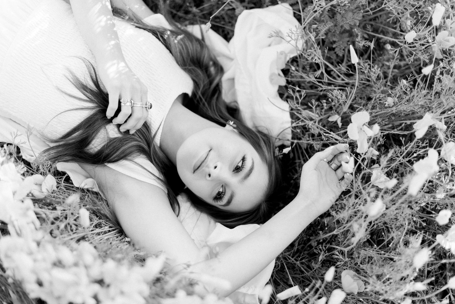 Black and white artistic portrait among blooming wildflowers.