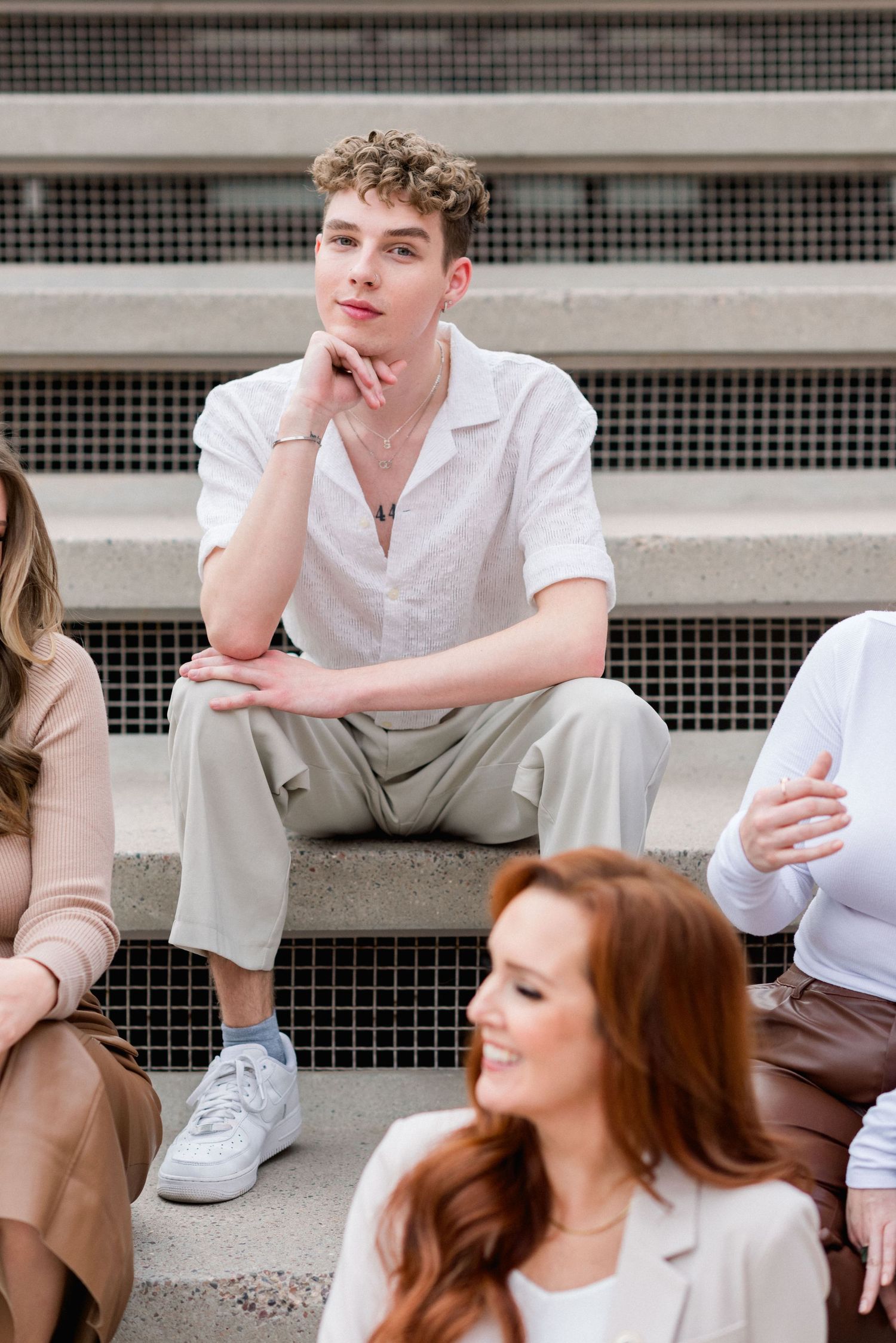 Group photo on concrete steps with modern architectural details in background.
