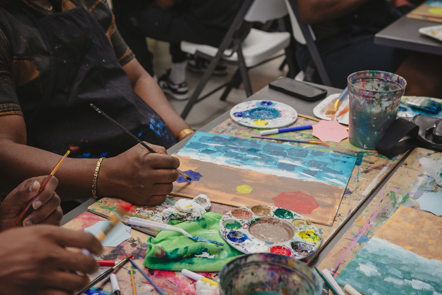 Close-up of guests painting on canvas during a creative workshop event, captured in a storytelling style by a Calgary event photographer