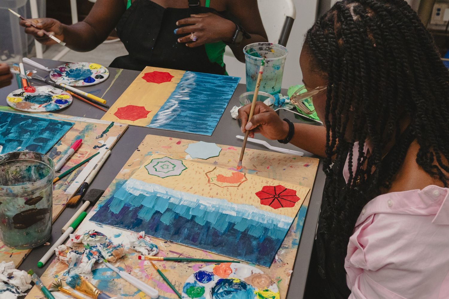 Close-up of a guest painting a colorful canvas during an interactive art event, captured by a Calgary event photographer