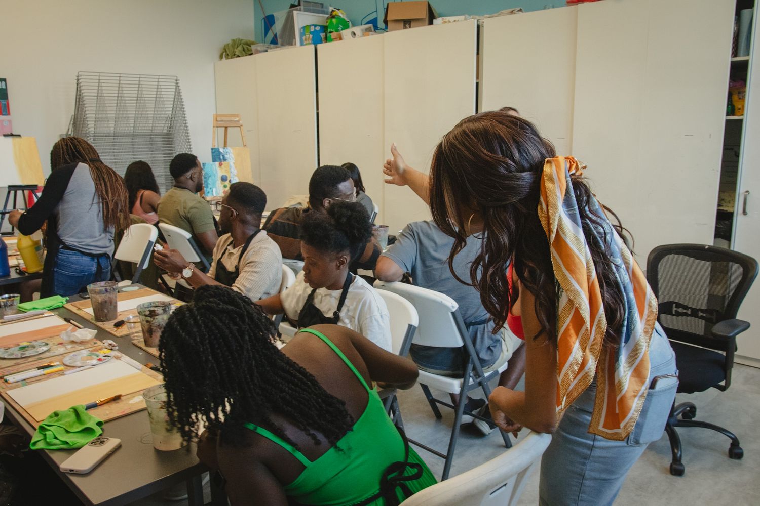 Guests engaging in a hands-on painting activity during a creative workshop event, captured in a candid storytelling style by a Calgary event