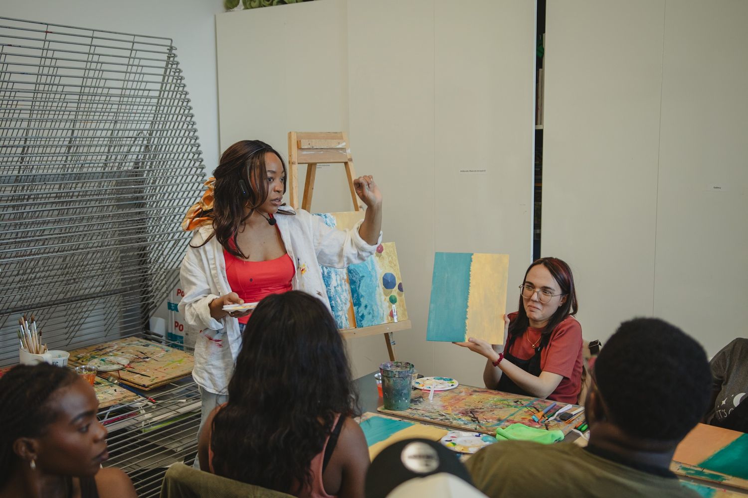 Instructor presenting artwork to a group during an interactive painting event, captured by a Calgary event photographer