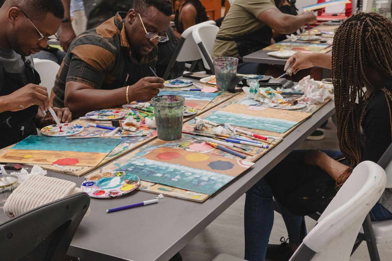 Close-up of guests painting on canvas during a creative workshop event, captured in a storytelling style by a Calgary event photographer
