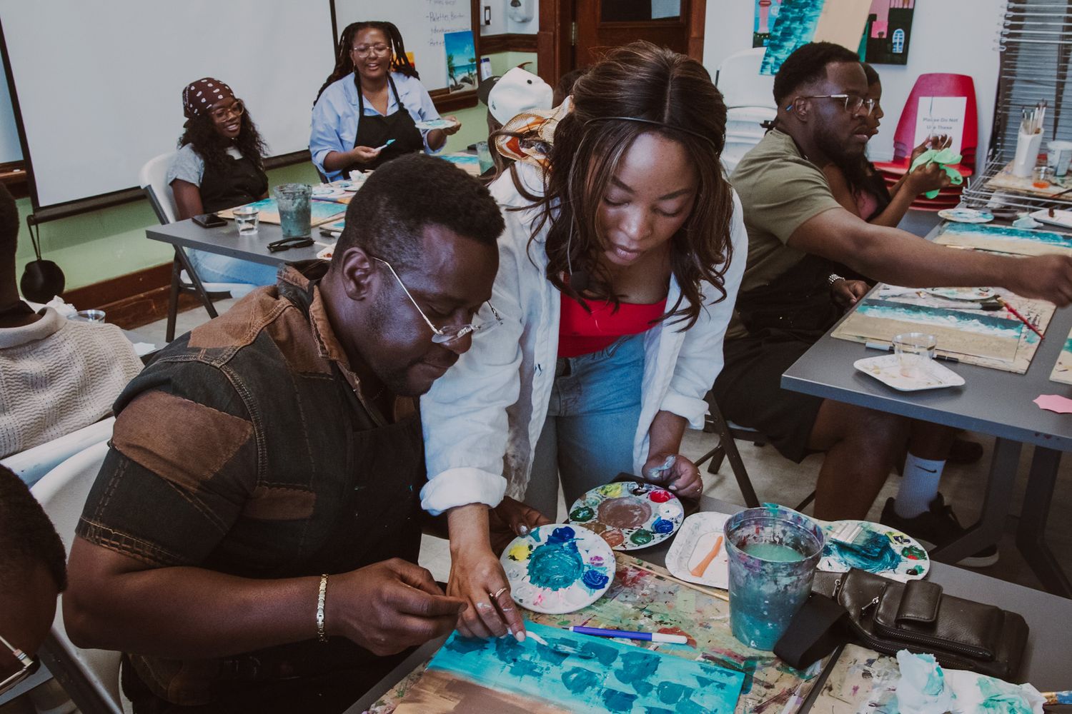 Close-up of guests painting on canvas during a creative workshop event, captured in a storytelling style by a Calgary event photographer