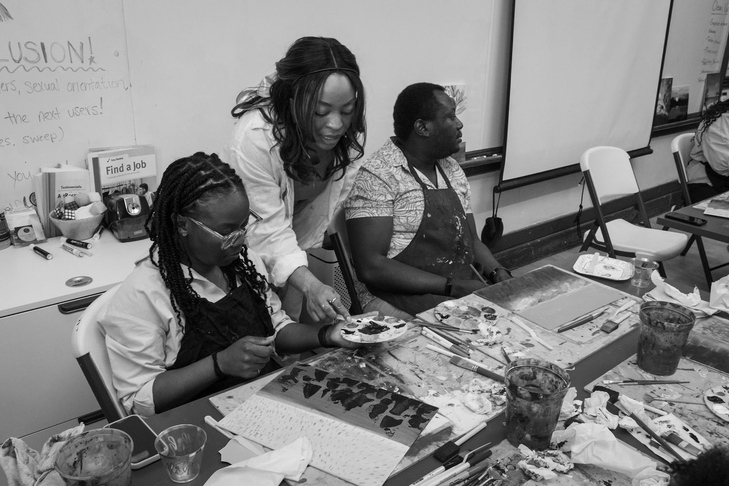 Guests engaged in a hands-on painting activity, captured in a timeless black and white style by a Calgary event photographer