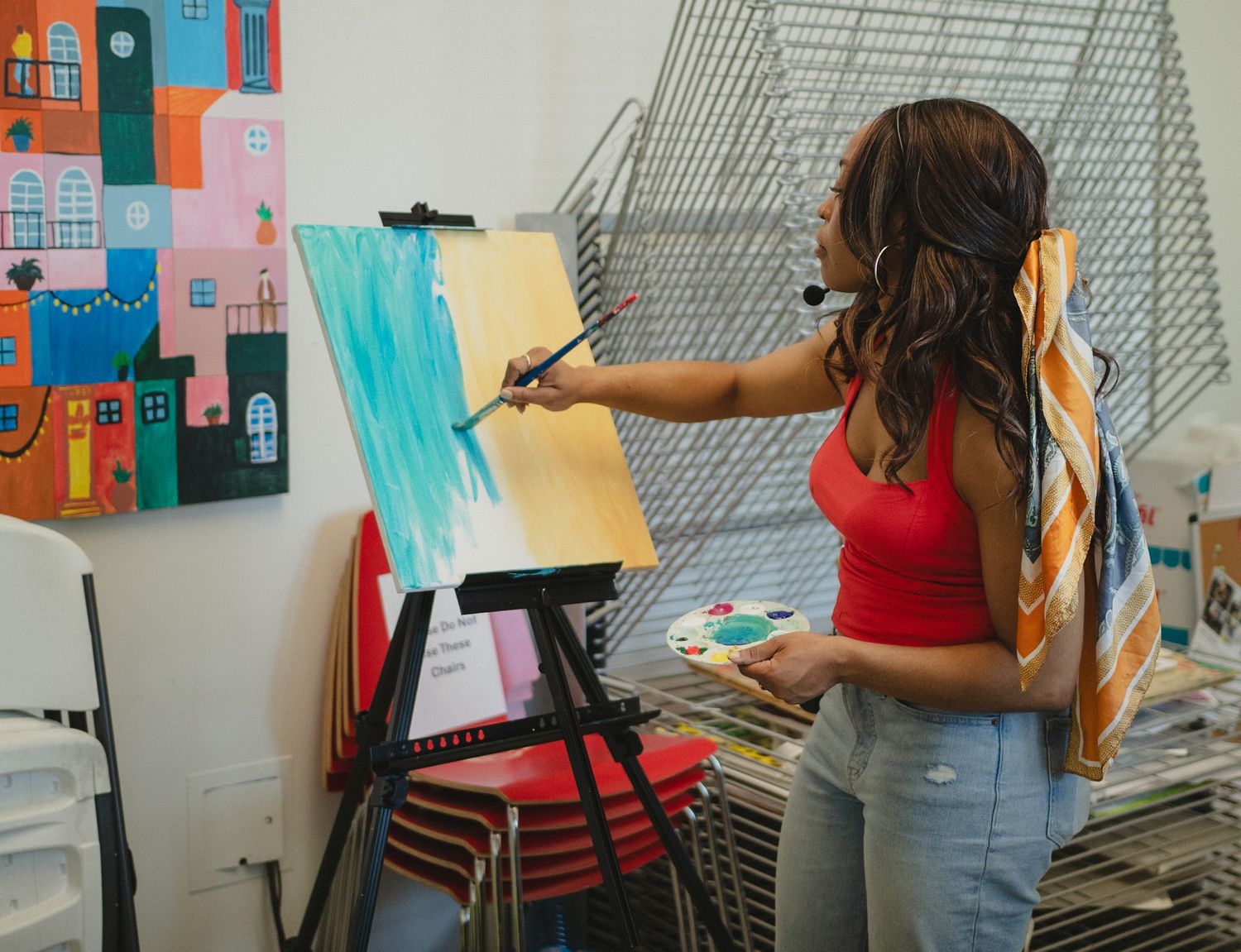 Woman painting on a canvas at an interactive art event, captured in a clean and candid style by a Calgary event photographer