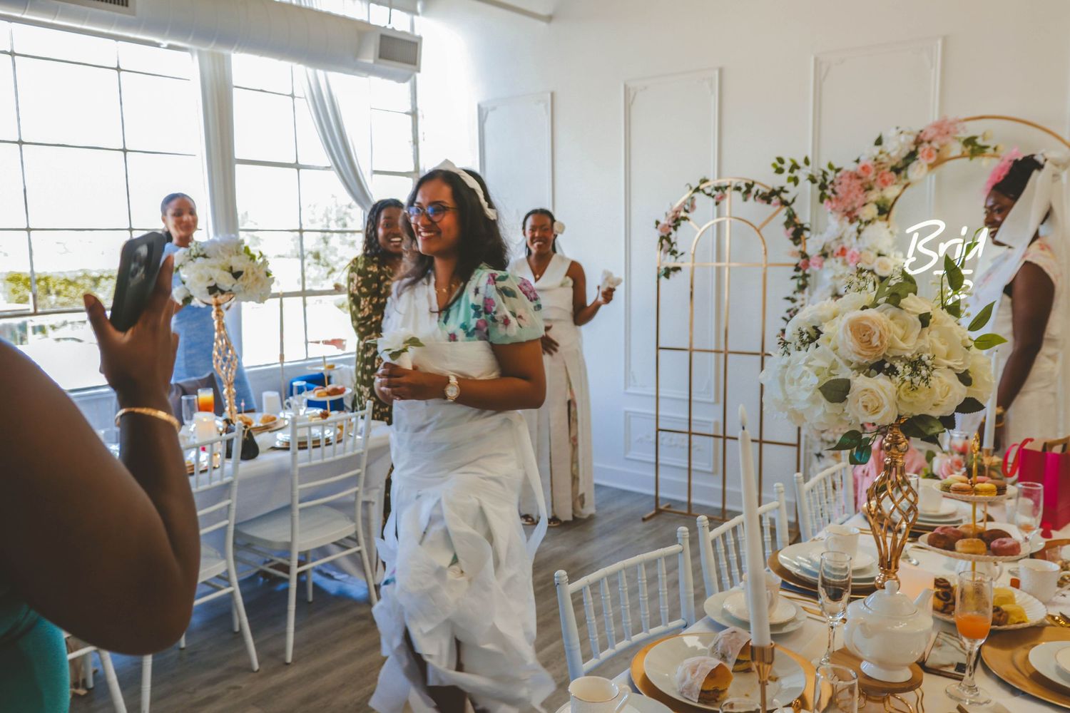 Bride-to-be walking into a decorated bridal shower with guests celebrating, captured in a candid storytelling style by a Calgary event photo