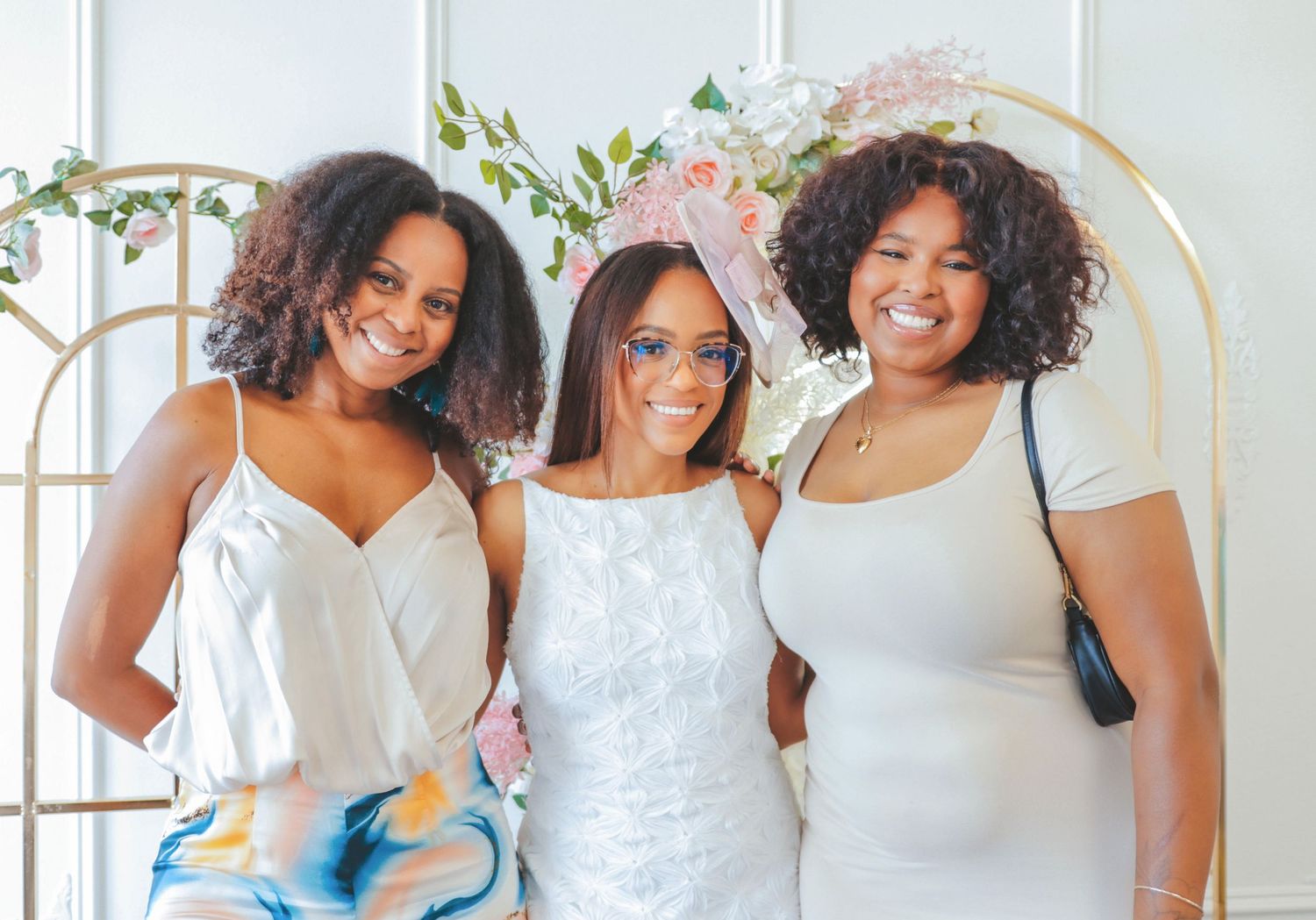 Three women smiling and posing together at a bridal shower in Calgary, captured by a Calgary event photographer