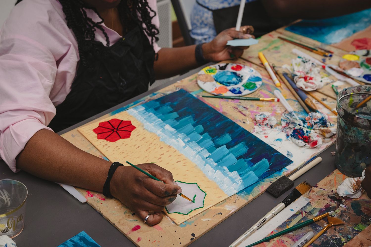 Close-up of a guest painting on canvas during a creative event, captured in a storytelling style by a Calgary event photographer