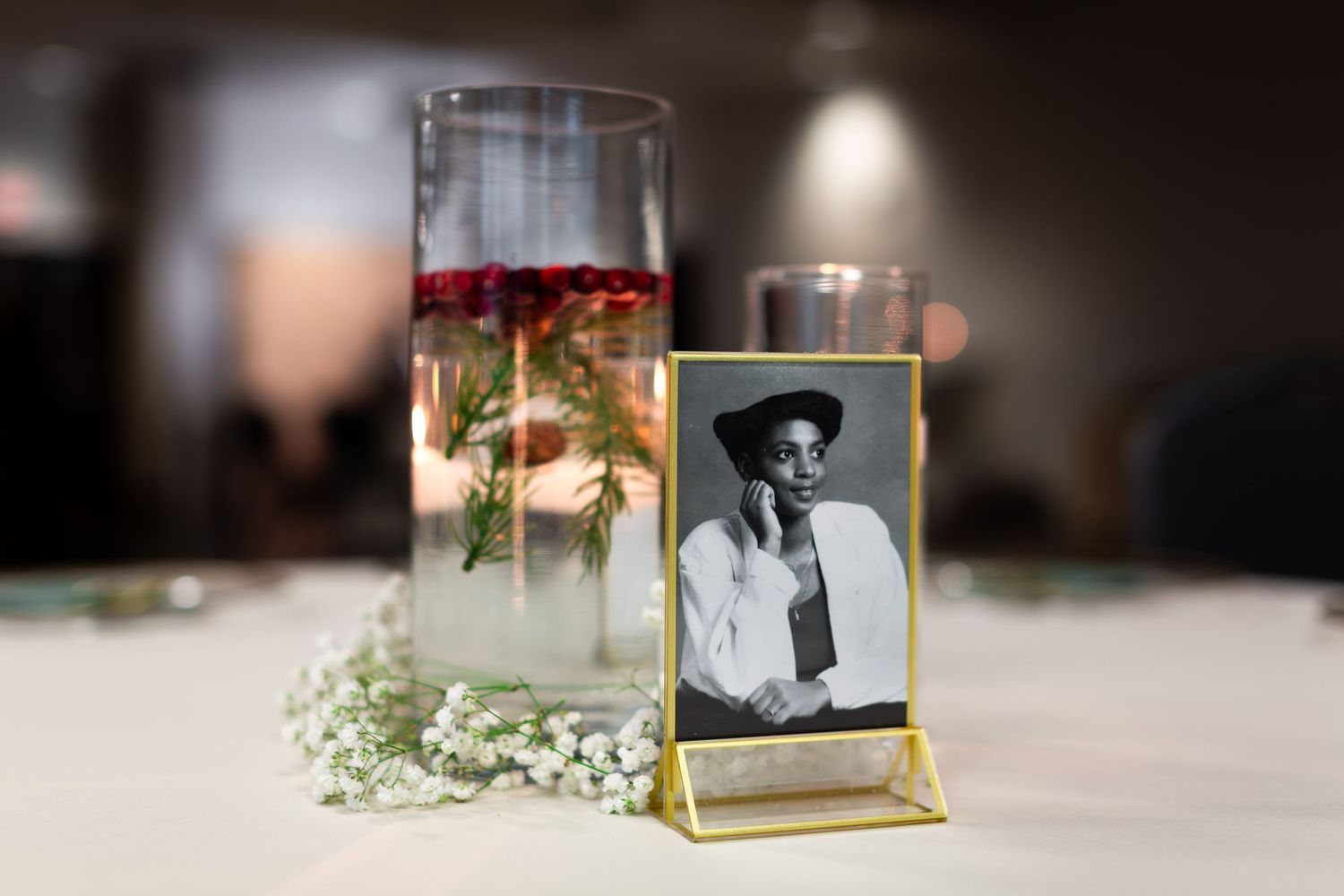 Vintage photographs displayed in glass frames with delicate baby's breath flowers as decorative accents.
