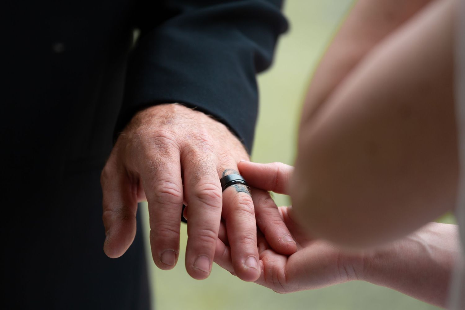 Close-up shot of hands exchanging wedding rings during a ceremony.