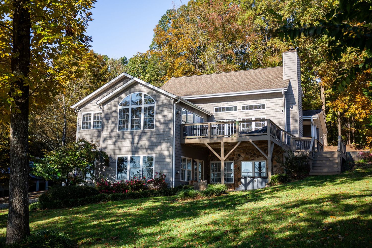 White residential buildings nestled among autumn trees on a hillside property.