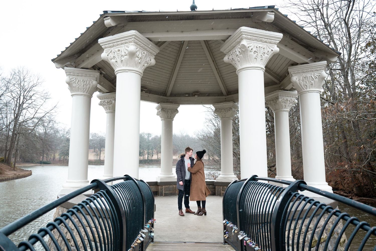 A series of connected photos showing a white gazebo with ornate columns and black railings in a park setting.