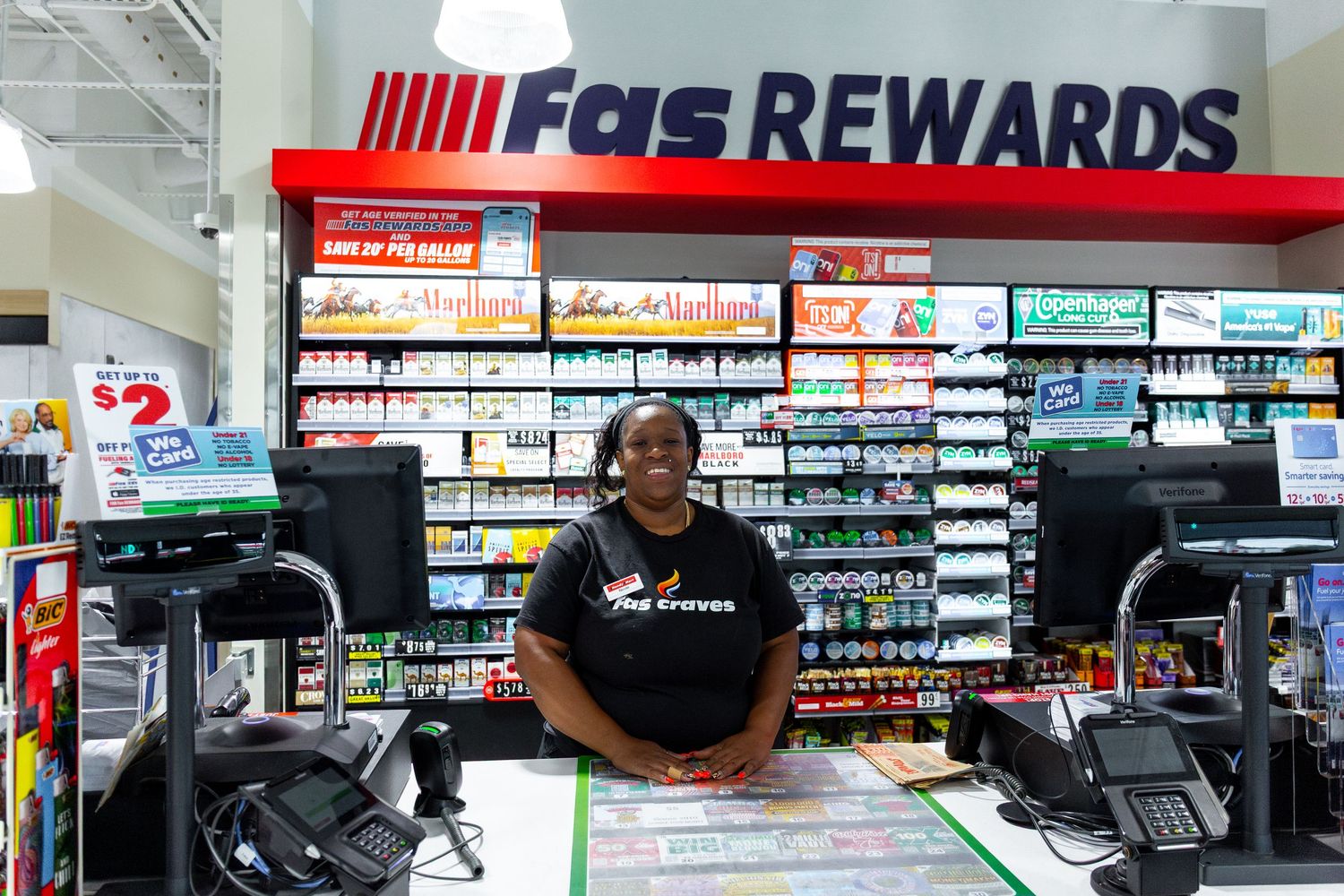 A panoramic view of a convenience store interior showing shelves of products and retail displays with FGS Rewards signage.