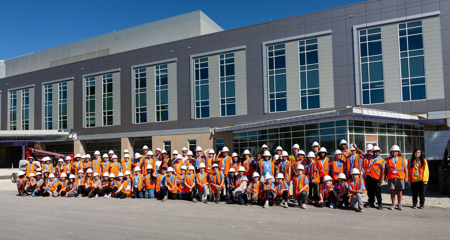 Long panoramic view of a modern commercial building exterior with large windows and white facade.