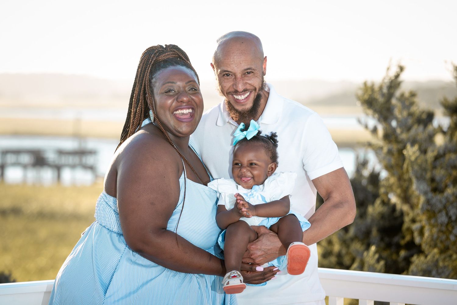 Family enjoying quality time together at the beach in matching light blue outfits.