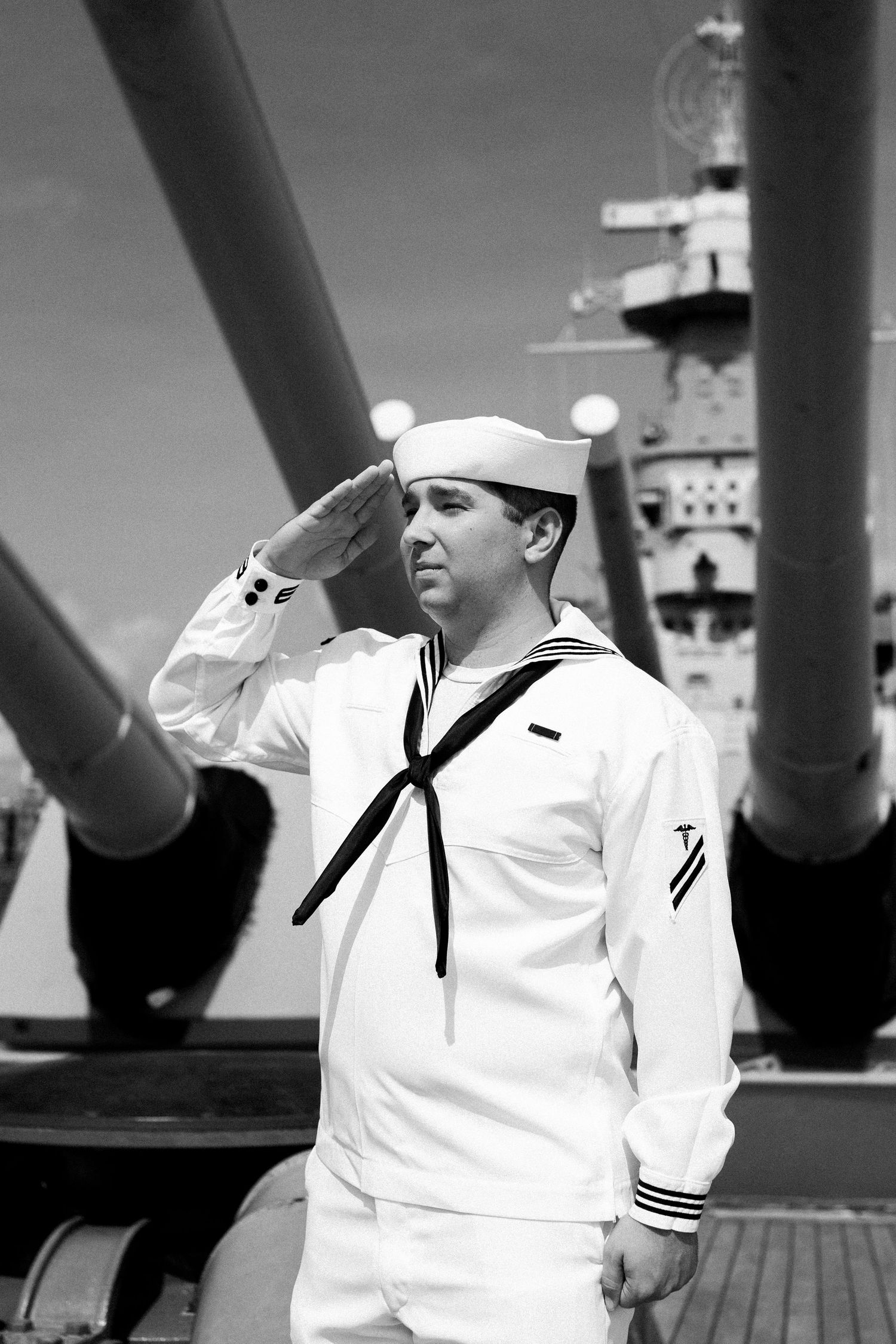 A black and white photo sequence shows a sailor in white uniform on a naval vessel's deck.