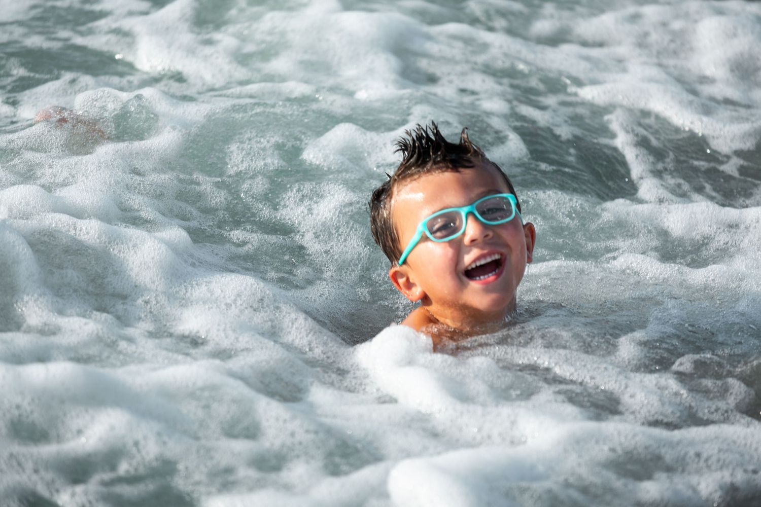 Close-up shots of someone enjoying waves in turquoise ocean water.