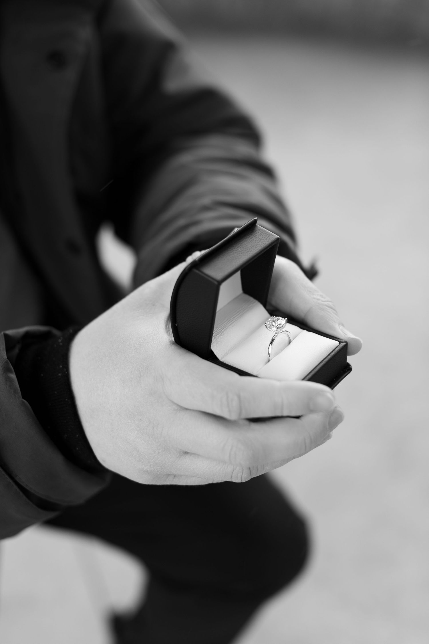 Black and white photo series showing hands in sequence folding an origami shape against a light background.