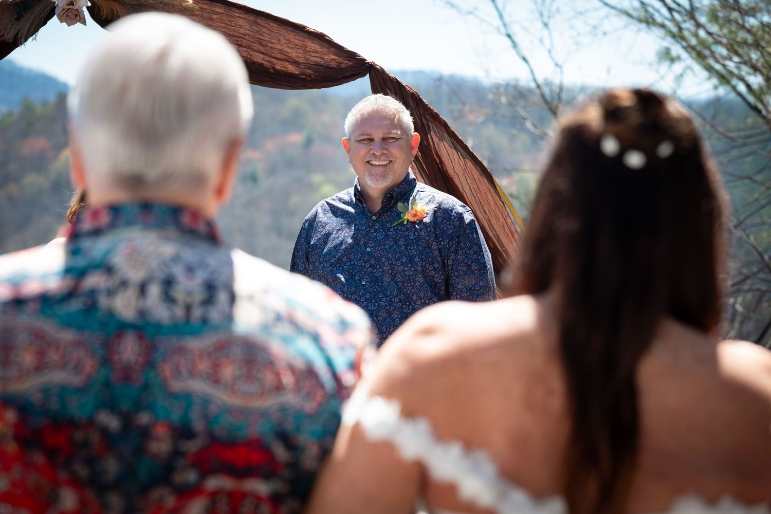 A series of candid moments at an outdoor wedding celebration with scenic mountain views in the background.