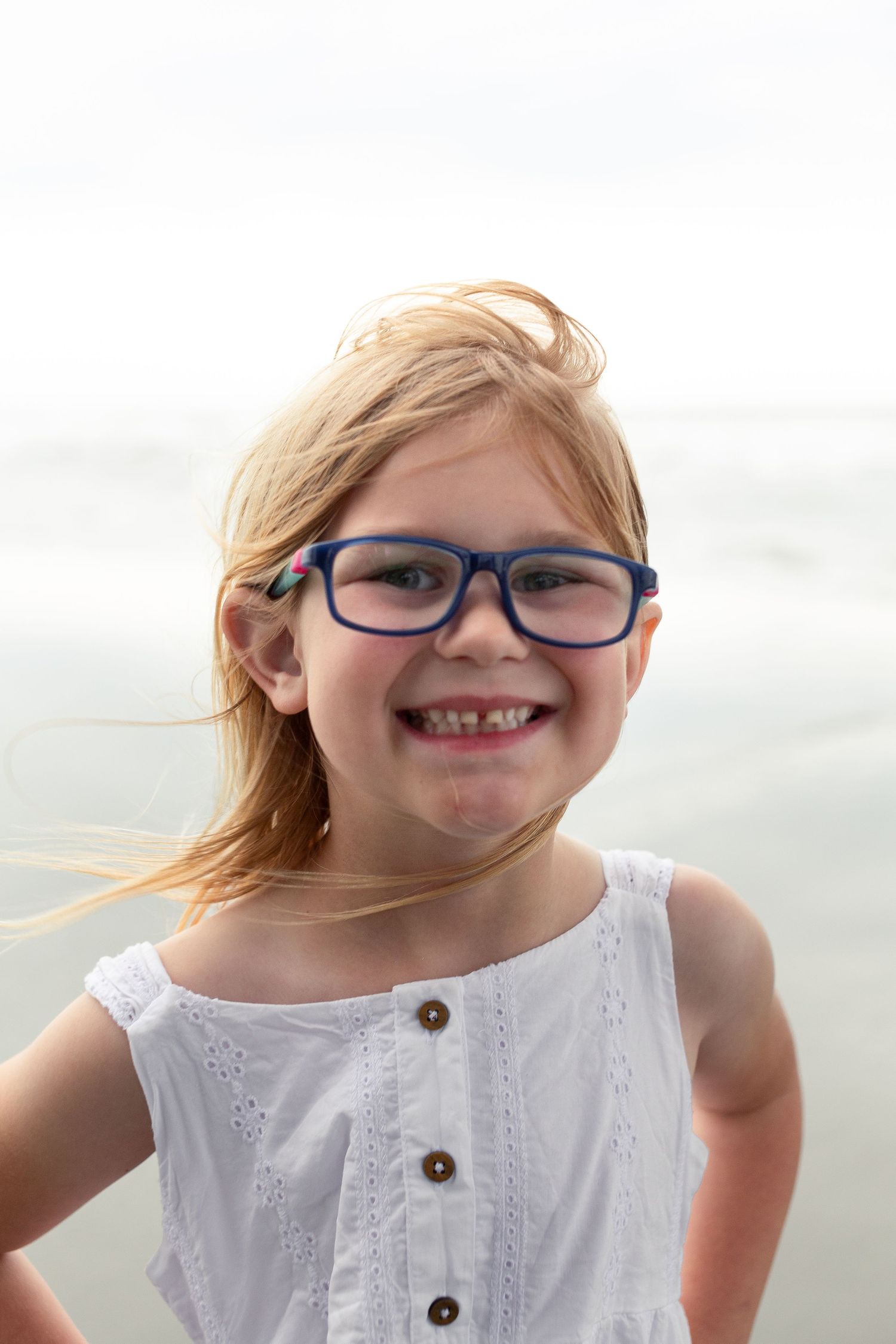 A series of playful expressions in white eyelet dress against a light background.