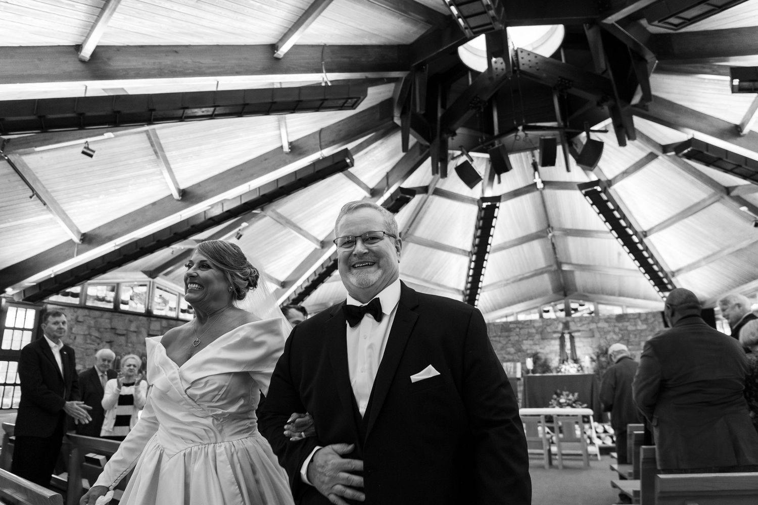 Black and white photo of a couple sharing a romantic moment during their wedding reception at a covered venue.