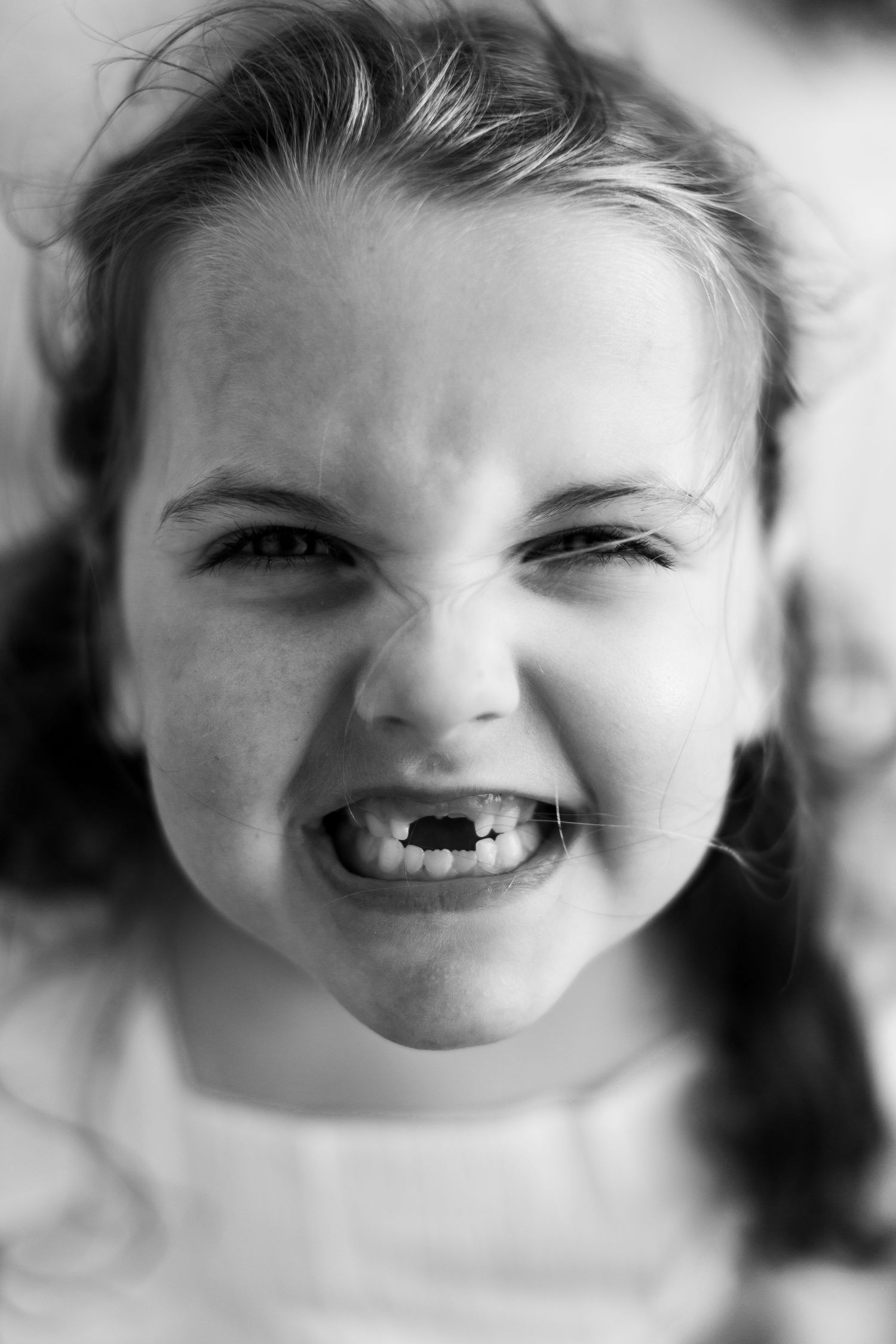 Black and white close-up portrait series showing joyful expressions and laughter.