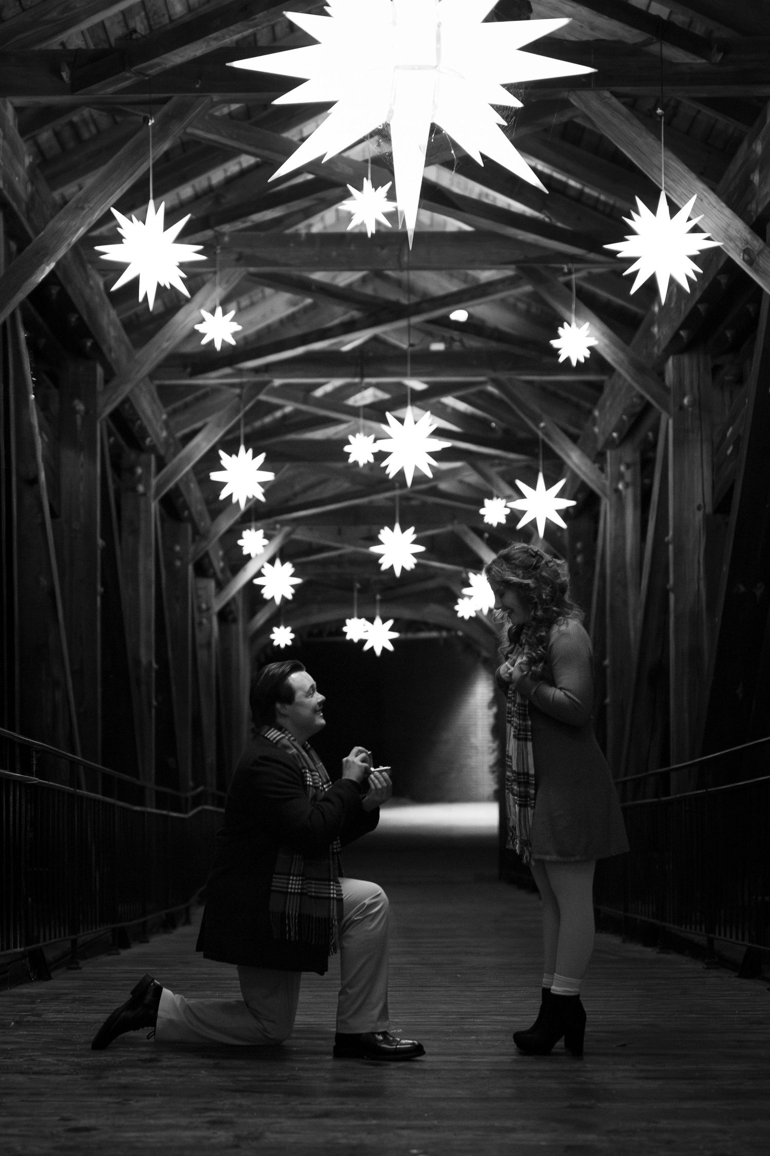 A black and white photo series showing silhouettes dancing under illuminated star-shaped lights in a dark corridor.
