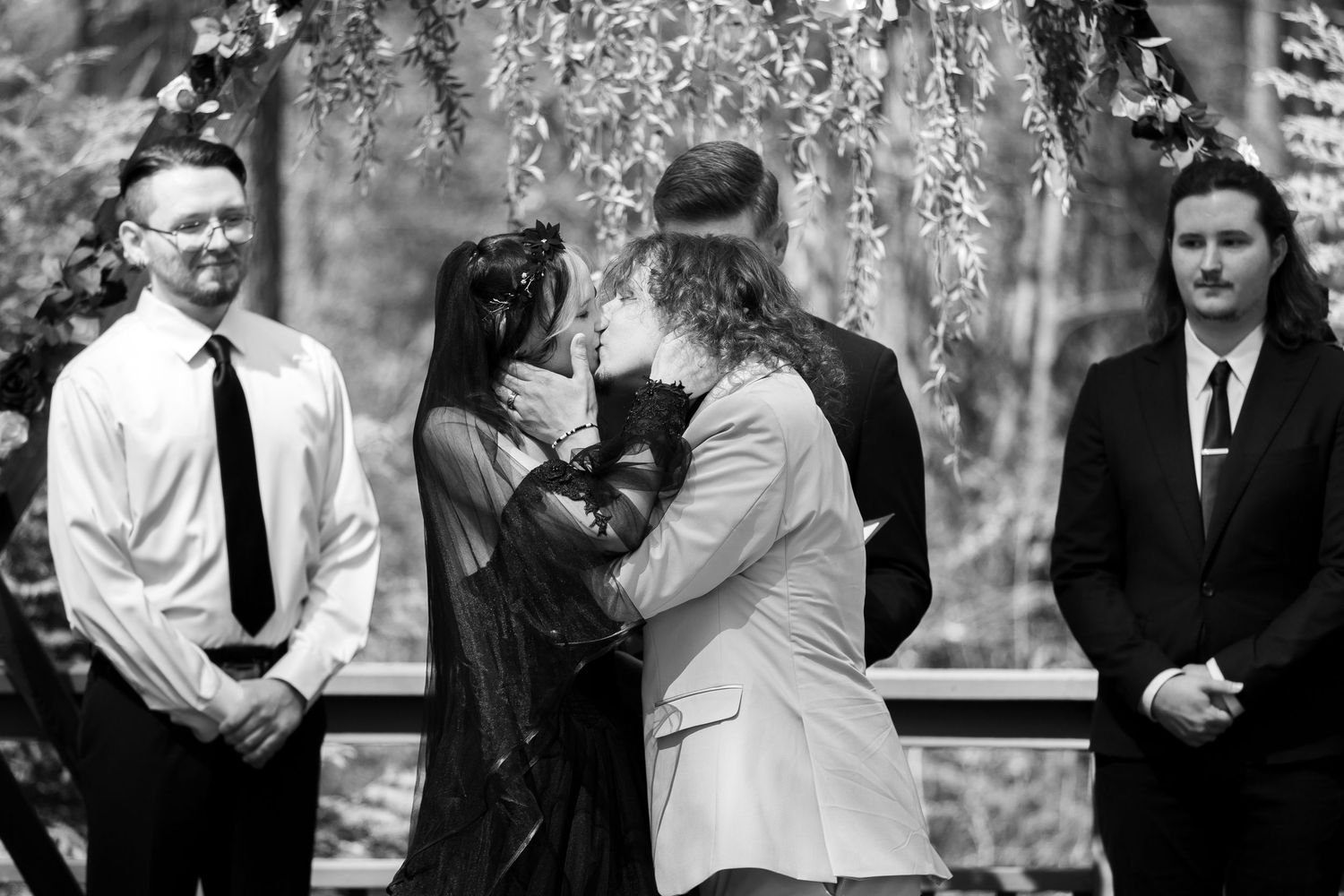 A series of black and white wedding photographs showing candid moments between couples and guests at an outdoor celebration.