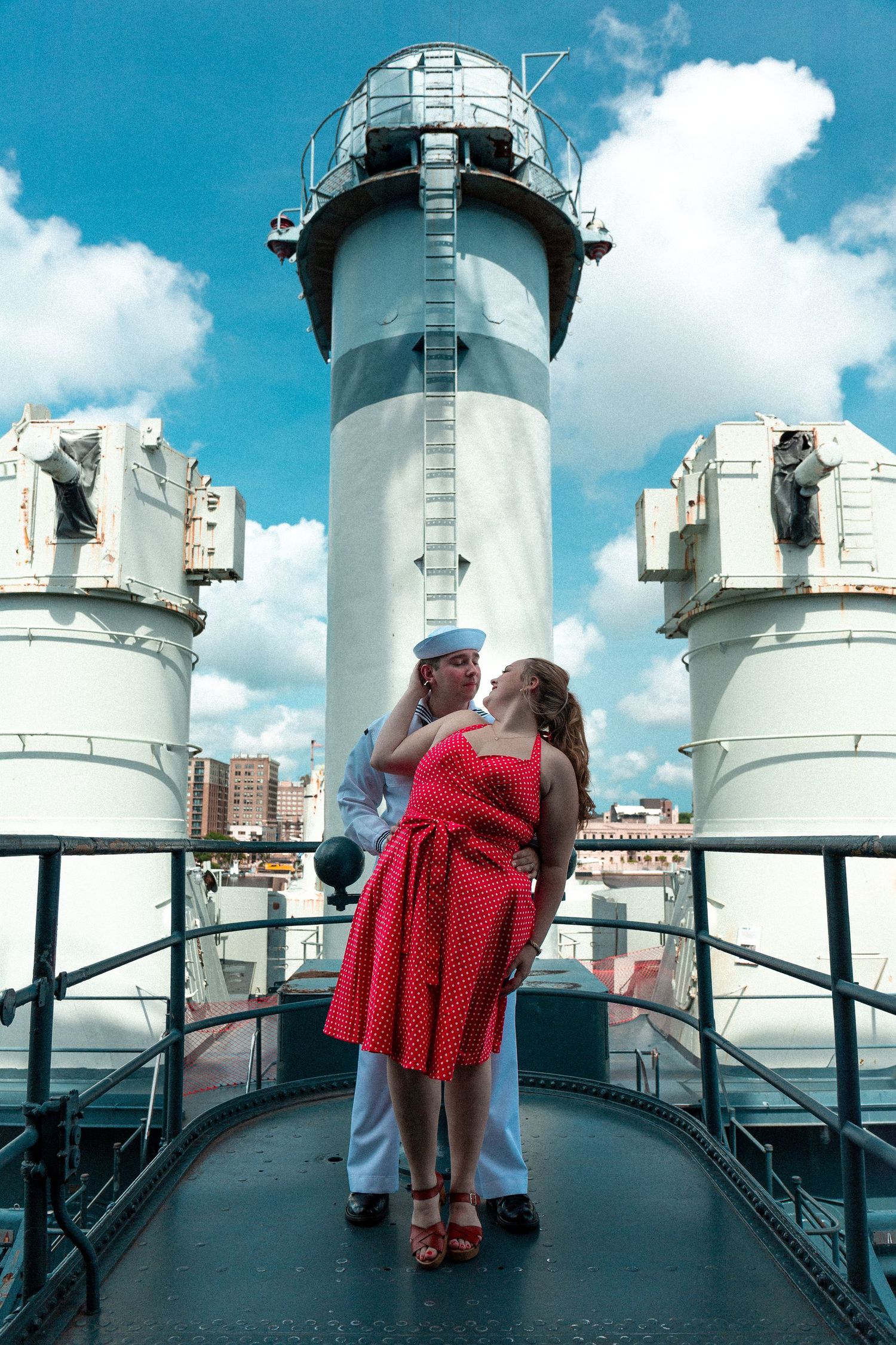 A sequence of photos showing people in 1950s attire posing near white ship smokestacks against a blue sky.