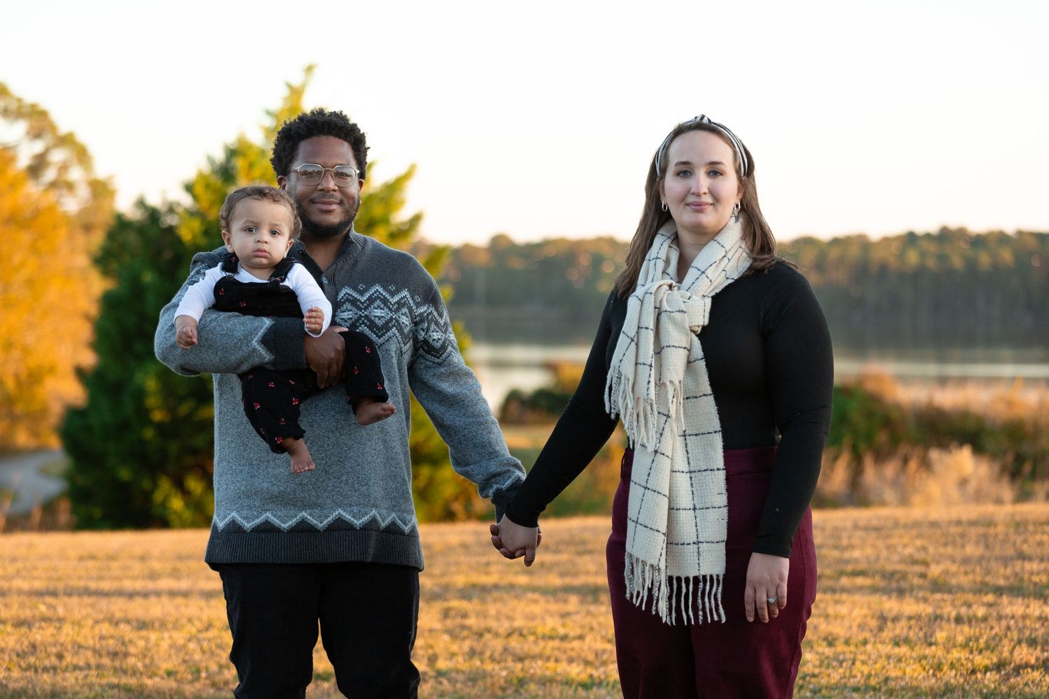 Autumn outdoor family portraits in a golden field at sunset.