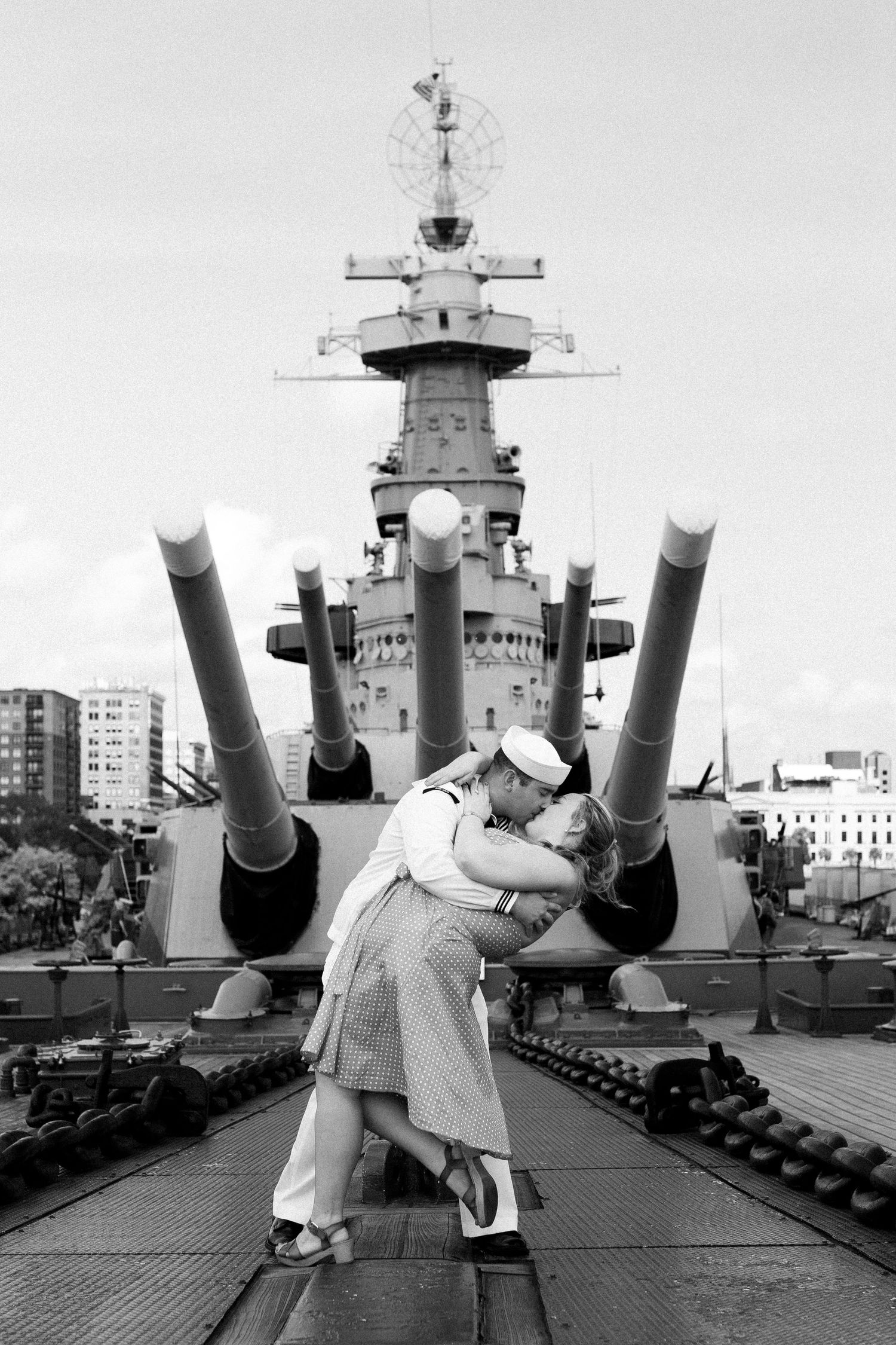 A series of black and white photos showing a sailor posing with large naval guns on a battleship deck.